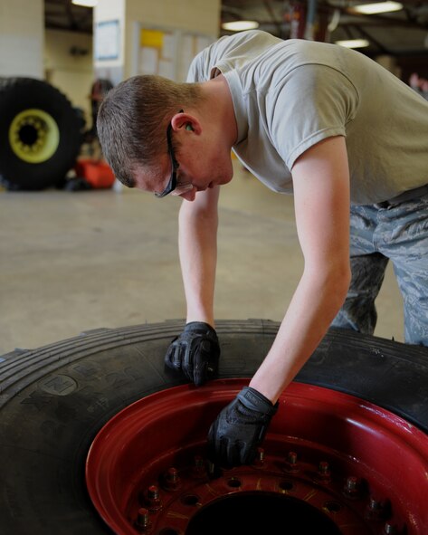 Airman 1st Class Zachary Meche, 2nd Logistics Readiness Squadron Vehicle Maintenance Allied Trades section, removes a valve core from a P-23 tire on Barksdale Air Force Base, La., April 16, 2014. Before beginning repair work on the tire, the valve core is removed so the air pressure decreases. If the air pressure is not decreased, there is a high possibility parts on the tire might pop off during repair and cause bodily harm to the mechanic or individuals in the area. (U.S. Air Force photo/Senior Airman Benjamin Gonsier)
