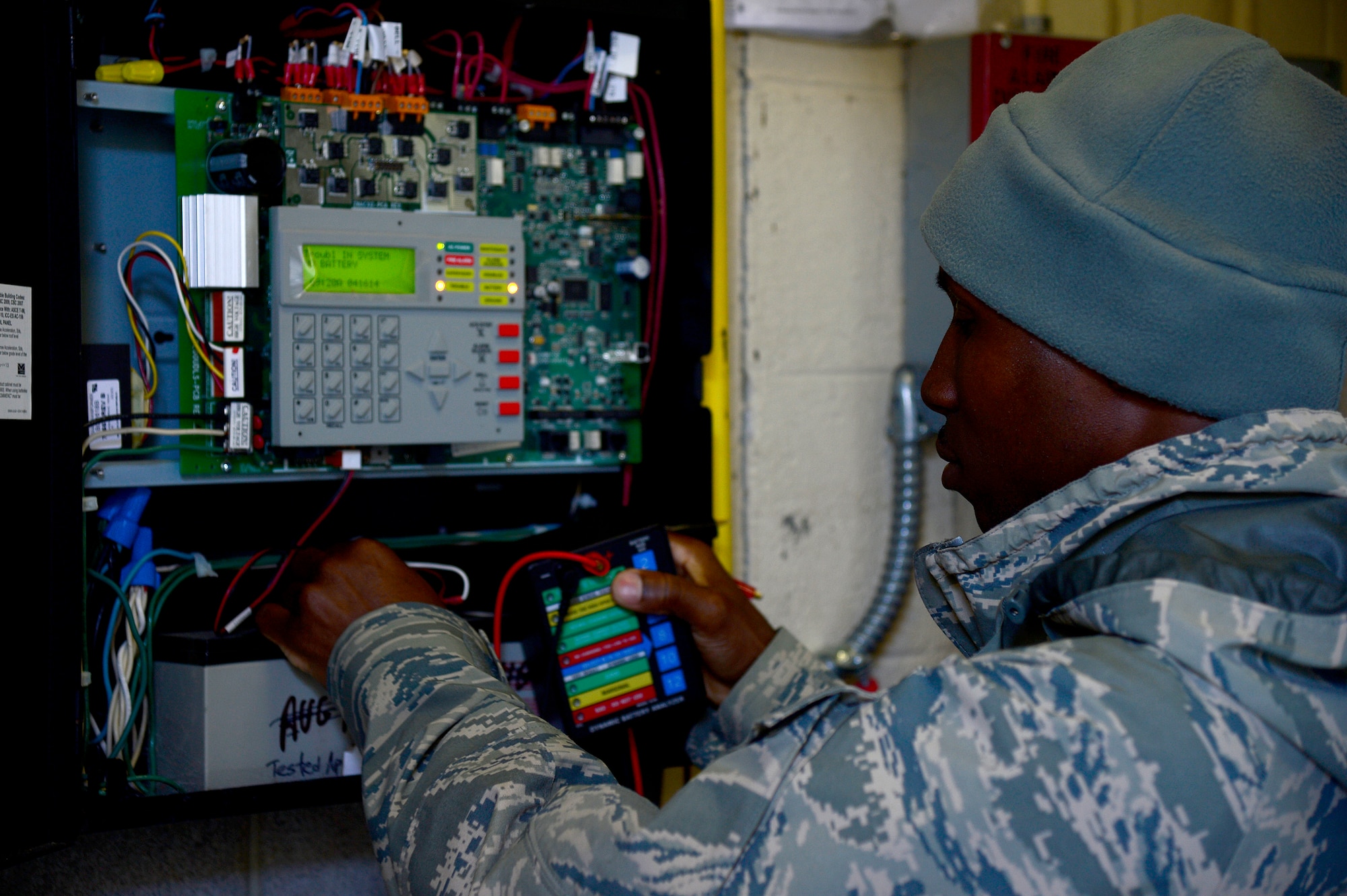 U.S. Air Force Staff Sgt. Mario Francis, 633rd Civil Engineer Squadron electrical systems craftsman, checks an alarm systems panel at Langley Air Force Base, Va., April 16, 2014. Francis is assigned to the alarm shop, which ensures systems used to report fire alarm activity to the fire department are working properly. (U.S. Air Force photo by Senior Airman Kayla Newman/Released)
