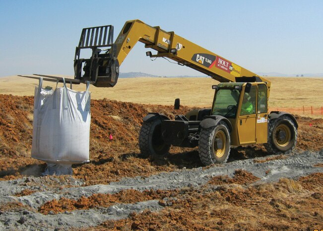 A forklift carries a bag of stabilizer to combat lead-contaminated soil at one of seven closed small arms ranges prior to tilling and excavation at Beale Air Force Base, Calif. This process is a part of the Military Munitions Response Program, which excavated more than 17,000 tons of contaminated top soil as part of the Interim Removal Action. (Courtesy photo)
