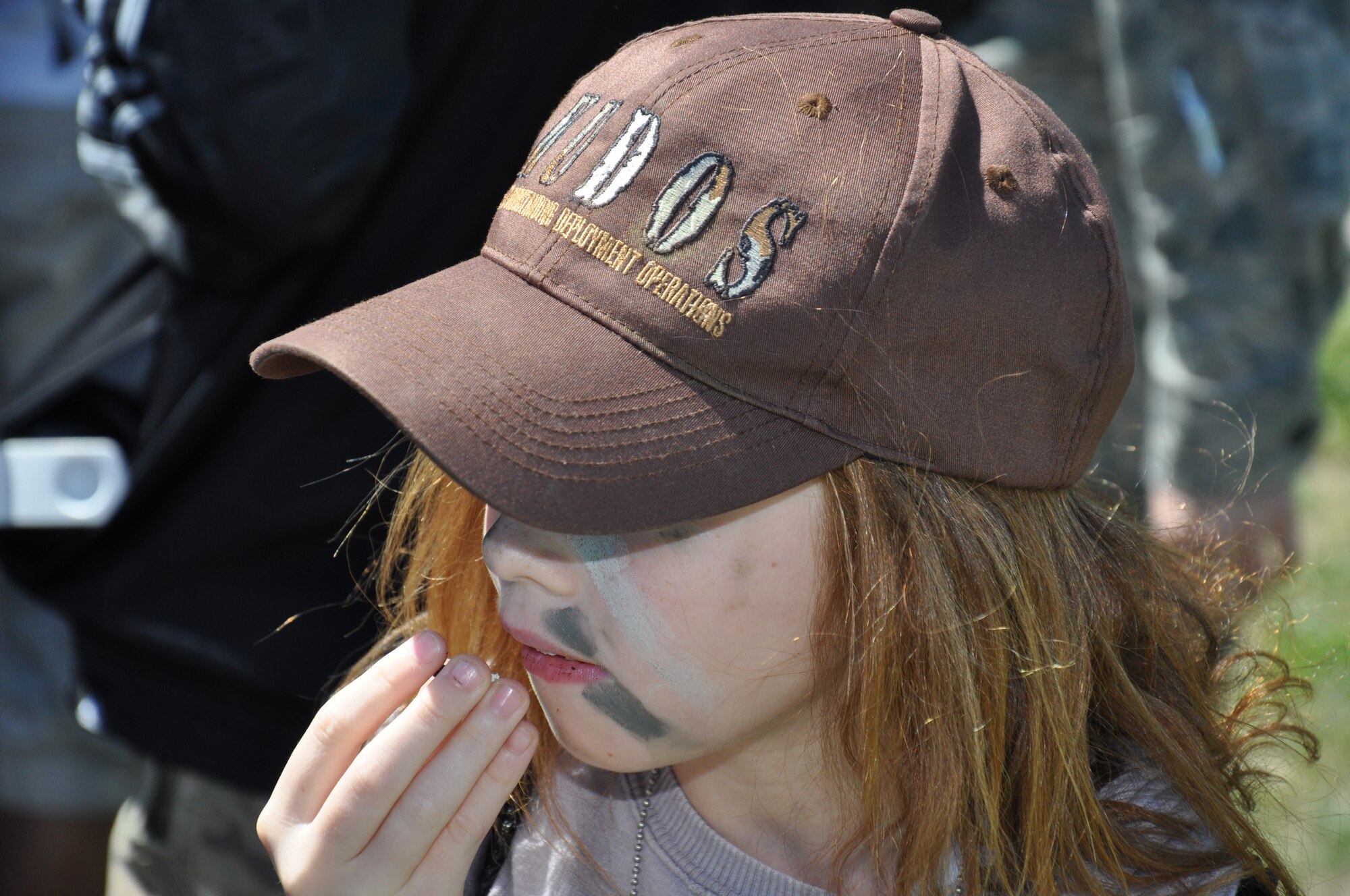 A child eats a snack while transitioning from the USO tent to the fire truck display on base X during Kids Understanding Deployment Operations April 12 at Travis. Approximately 290 children, ages 5 to 12 attended the event and were exposed to many different stations that highlight what service members experience while preparing for deployment. (U.S. Air Force photo/ Staff Sgt. Christopher Carranza)