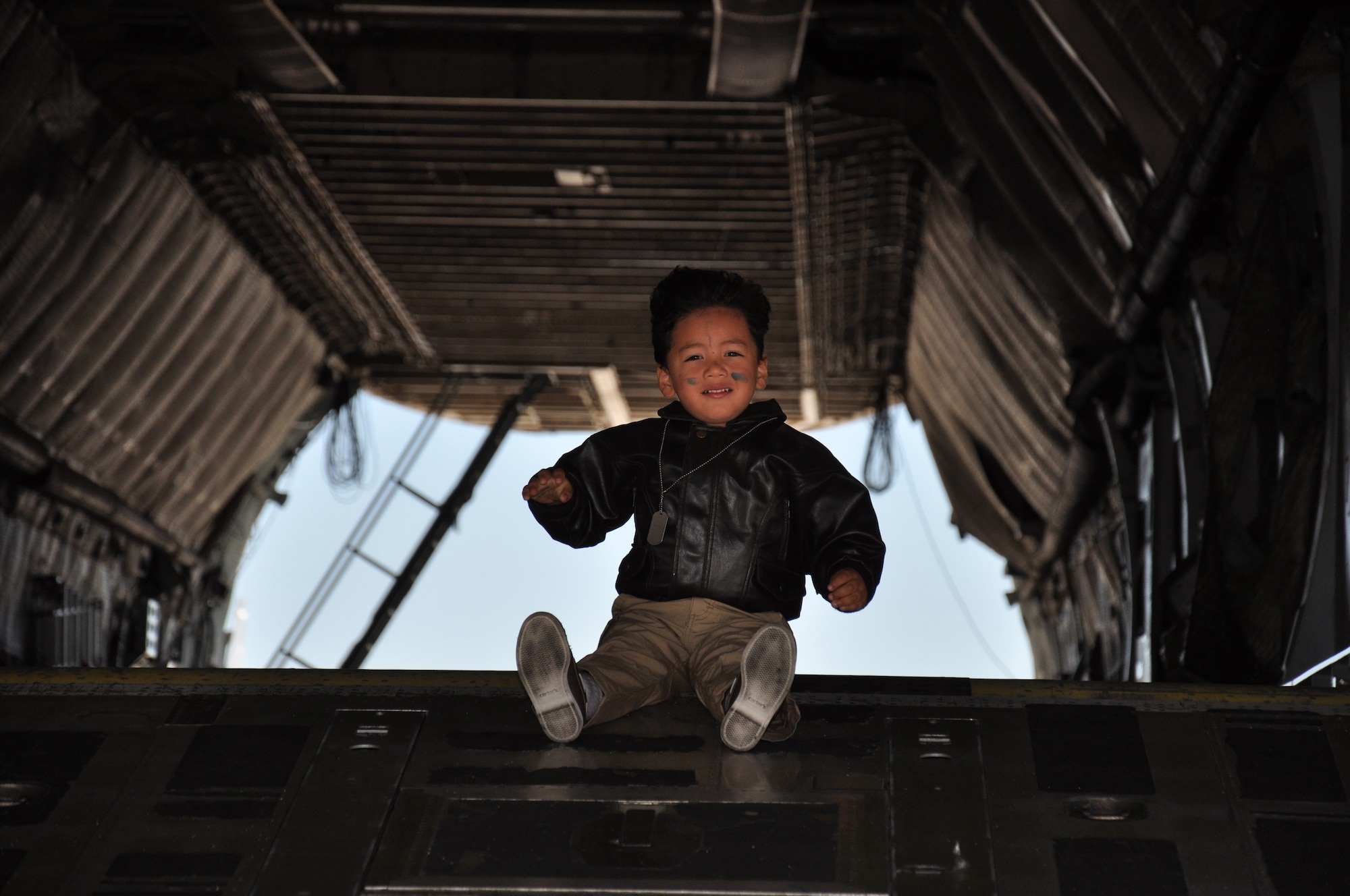 A child sits on the rear ramp of a C-5 Galaxy April 12 during Kids Understanding Deployment Operations at Travis. The event featured static aircraft and many other hands-on displays from various base agencies to help kids understand deployments. (U.S. Air Force photo/Staff Sgt. Christopher Carranza)