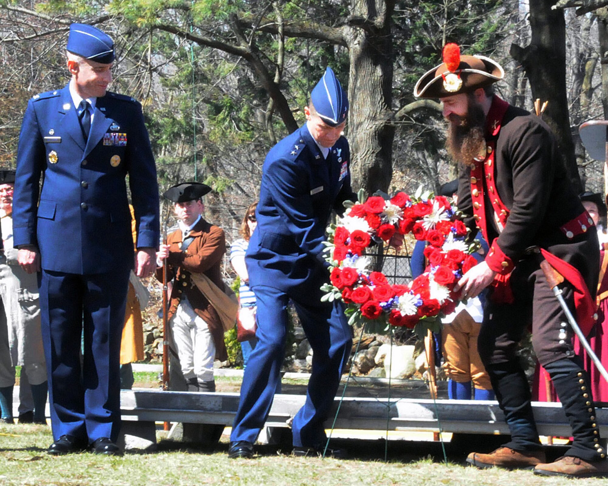 BEDFORD, Mass. – Maj. Gen. Craig S. Olson (center), C3I and Networks program executive officer, assists a Revolutionary War reenactor place a wreath at Wilson Park, the site where Bedford Minutemen gathered before marching to Concord April 19, 1775, at the start of the Revolutionary War as Col. Lester A. Weilacher, 66th Air Base Group commander, looks on. The wreath laying was part of the town of Bedford’s annual Pole Capping event April 12. A full listing of Patriot’s Day events scheduled in the local area can be found at www.nps.gov/mima/patriots-day.htm. (U.S. Air Force photo by Linda LaBonte Britt)