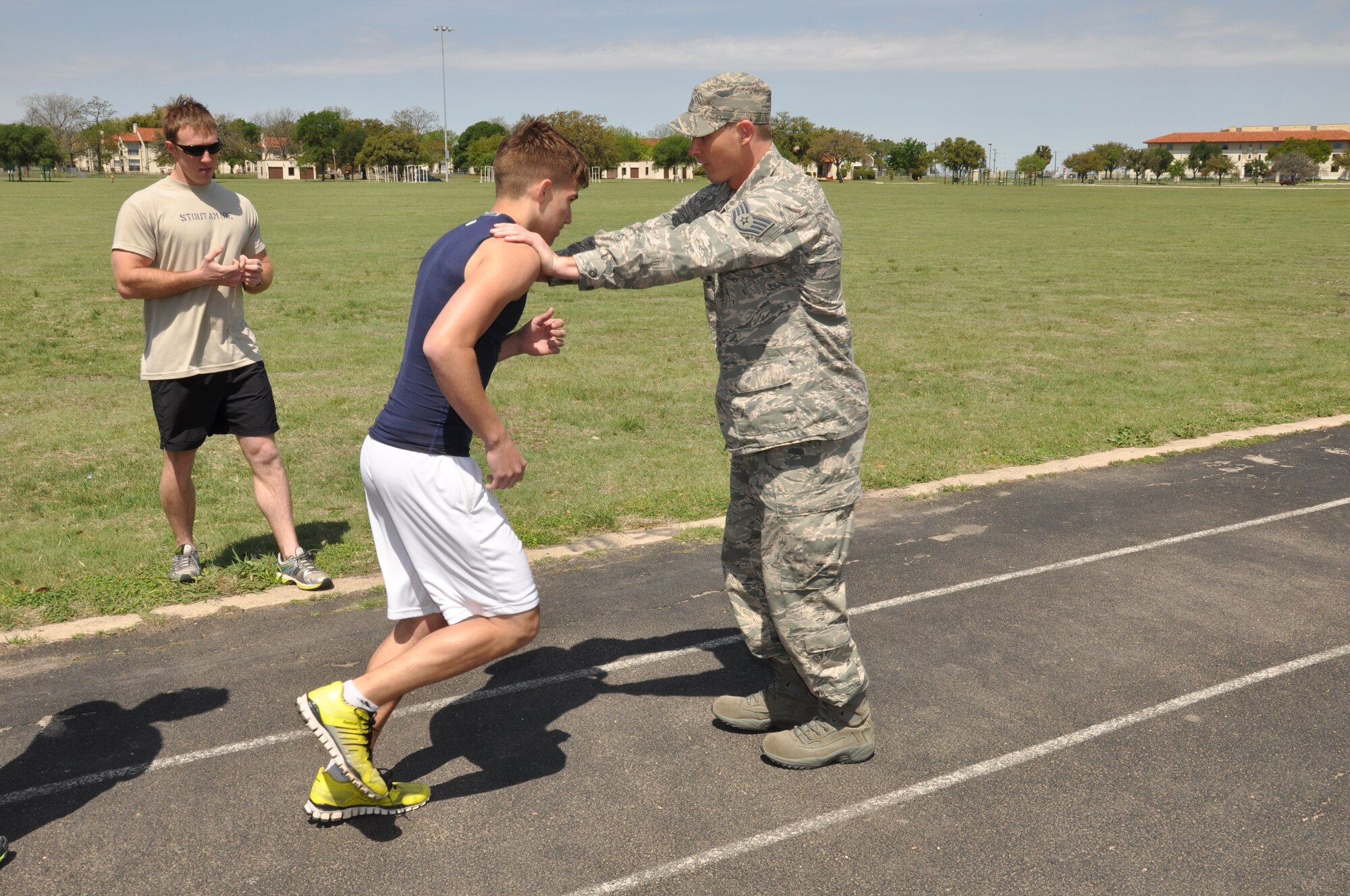 Staff Sgt. Bryan Berrio, 341st Recruiting Squadron recruiter (right), and Airman 1st Class Collin Stoutamire, 23rd Special Tactics Squadron pararescue specialist (left), teach members of the Delayed Entry Program proper running techniques at Joint Base San Antonio-Fort Sam Houston, Texas, April 4. Stoutamire, who participated in the Recruiter Assistance Program, mentored DEP members on effective techniques to help them on their upcoming Physical Ability and Stamina Test. (U.S. Air Force photo/Tech. Sgt. Hillary Stonemetz)