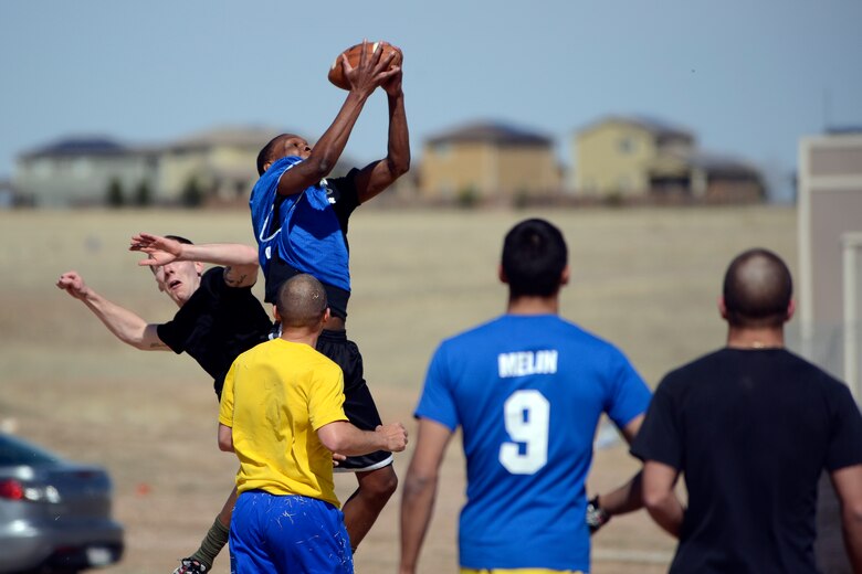Airmen with the 50th Contracting Squadron play flickerball during their physical training April 11, 2014, at the Schriever Fitness Center. Flickerball is a group sport played with an American football in similar situations to ultimate frisbee. (U.S. Air Force photo/Christopher DeWitt)