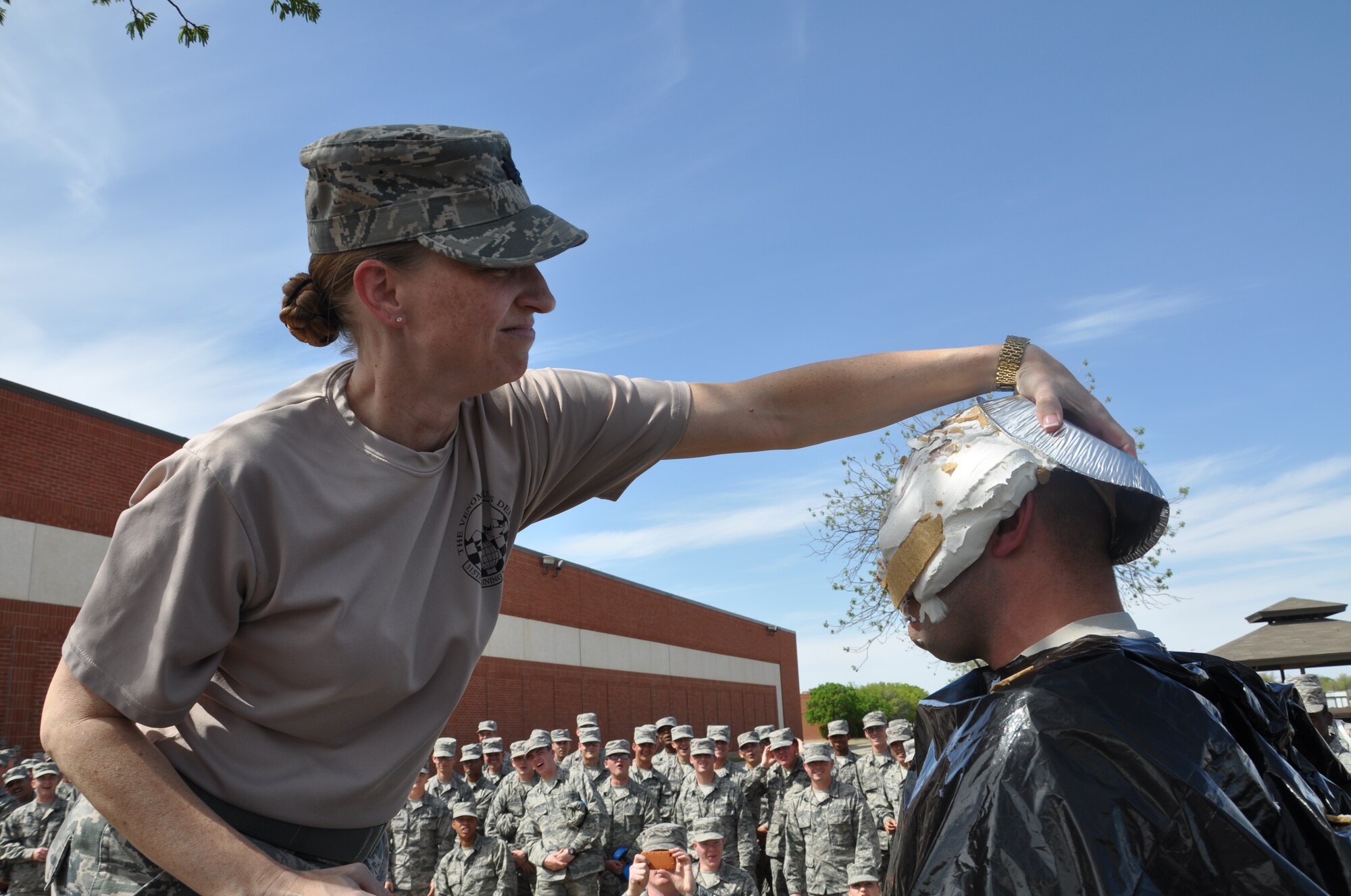 GOODFELLOW AIR FORCE BASE, Texas – Lt. Col. Caeli Hull, 315th Training Squadron Commander, pies Senior Master Sgt. Chris Chabot, 315th TRS Flight Chief during an Air Force Assistance Fund event outside the 315th TRS here Aug. 11. The Air Force Assistance Fund is a 6 week fundraising drive in which funds go to Air Force Members and their families. (U.S. Air Force photo/ Tech. Sgt. Jared Whitecar)