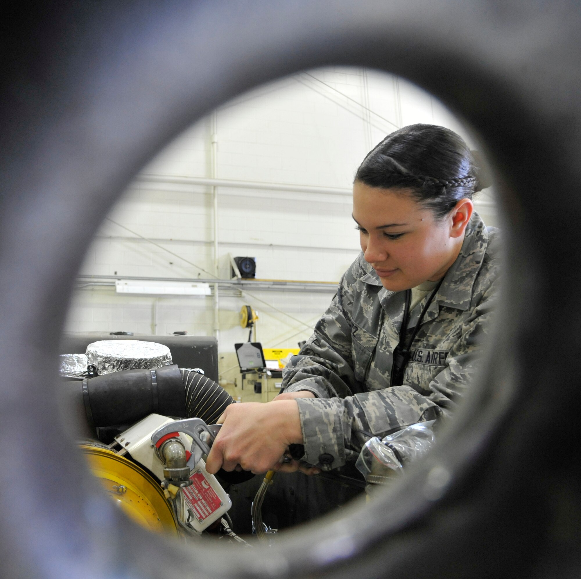 Airman 1st Class Laura Reitz, 509th Maintenance Squadron aerospace ground equipment journeyman, loosens a cannon plug on a negative 60 gas turbine compressor at Whiteman Air Force Base, Mo., April 9, 2014. The compressor is used to supply power and compressed air to the aircraft. (U.S. Air Force photo by Airman 1st Class Keenan Berry/Released)