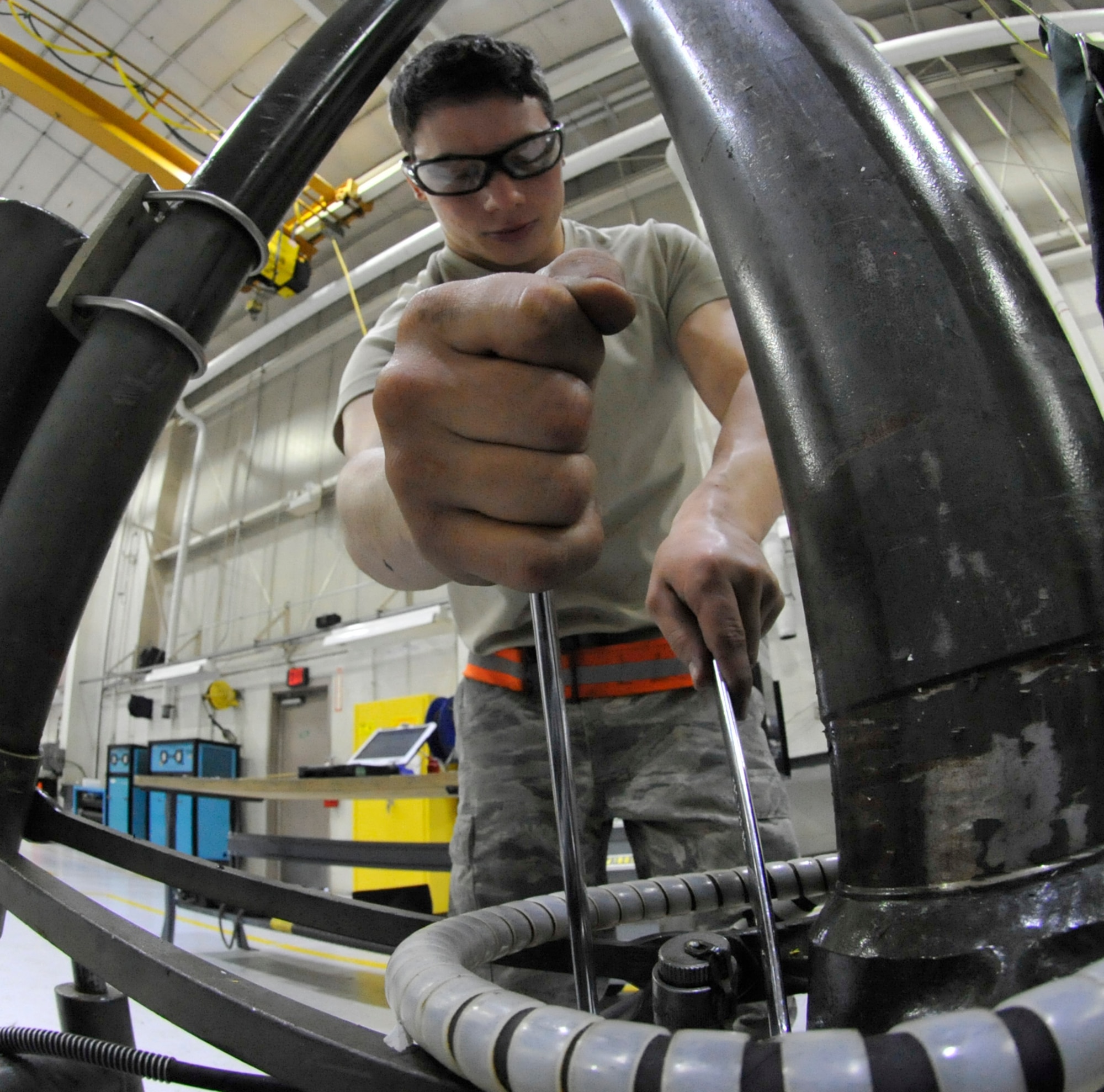 Airman 1st Class Lance Lockett, 509th Maintenance Squadron aerospace ground equipment apprentice, removes a hydraulic line from a 30-ton jack at Whiteman Air Force Base, Mo., April 9, 2014. This task is done in preparation for a new paint job, which helps prevent corrosion from occurring on jack. (U.S. Air Force photo by Airman 1st Class Keenan Berry/Released)