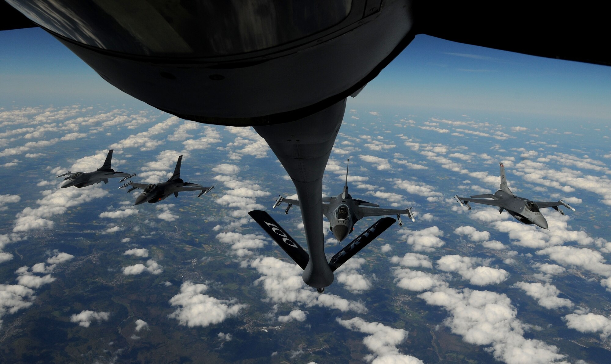 F-16 Fighting Falcons from Spangdahlem Air Base, Germany, fly in a formation over Germany, April 16, 2014, after receiving fuel from a KC-135 Stratotanker from RAF Mildenhall, England. Specialized KC-135s can refuel several types of receivers, even those that burn different types of gas, by using a system that segregates fuel tanks spread throughout the wings and belly of the airframe. (U.S. Air Force photo by Senior Airman Kate Maurer/Released)