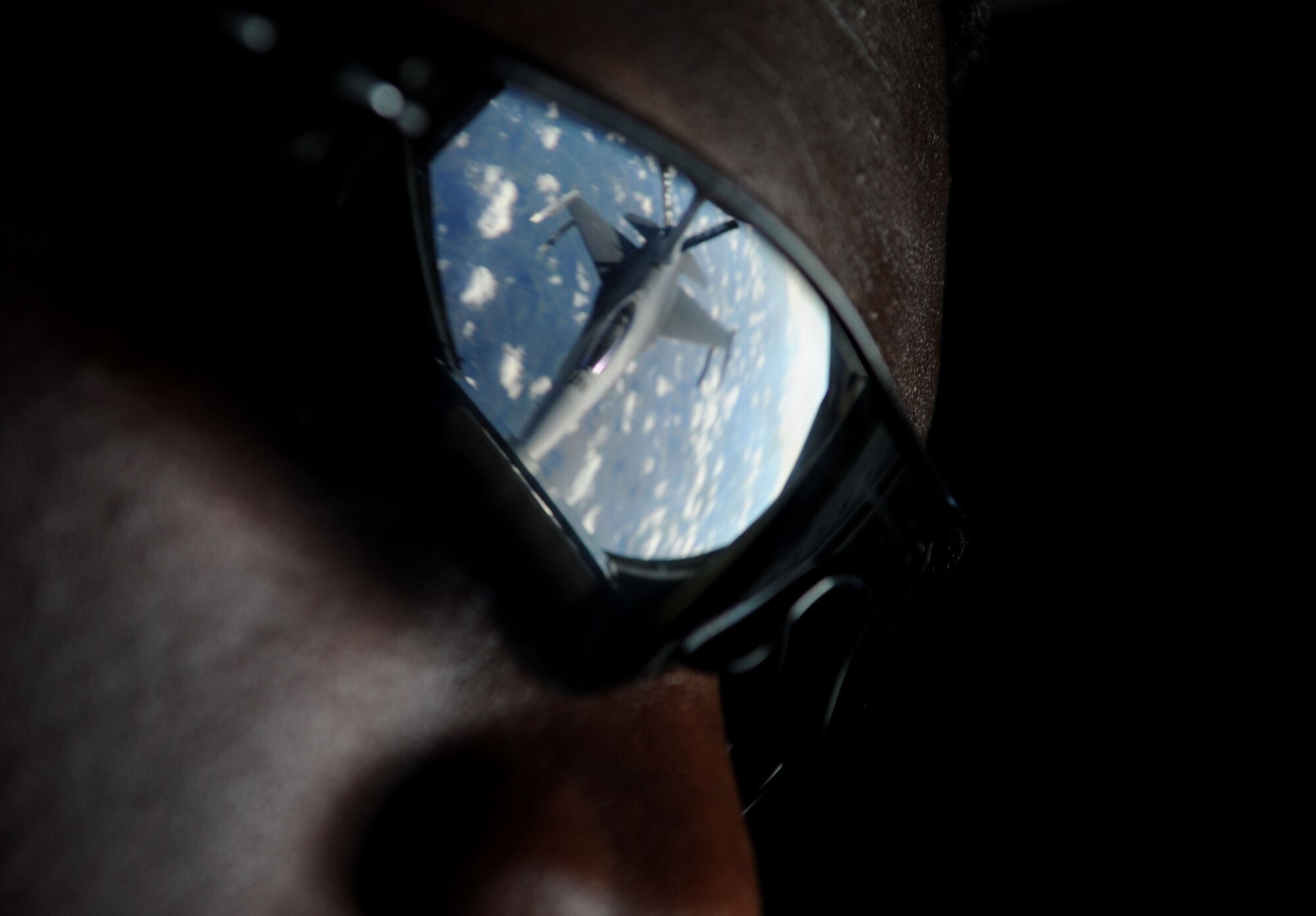 The image of an F-16 Fighting Falcon from Spangdahlem Air Base, Germany, shows on the sunglasses of Senior Airman Devaughn Granger, 351st Air Refueling Squadron boom operator from Rome, N.Y., while he controls the boom of a KC-135 Stratotanker April 16, 2014, over Germany. RAF Mildenhall's fleet has the capability to refuel any type of U.S. and allied aircraft using either a boom or wing-mounted drogue system. As a boom operator, Granger is the Airman responsible for guiding the boom and refueling the receiving aircraft. (U.S. Air Force photo by Senior Airman Kate Maurer/Released)