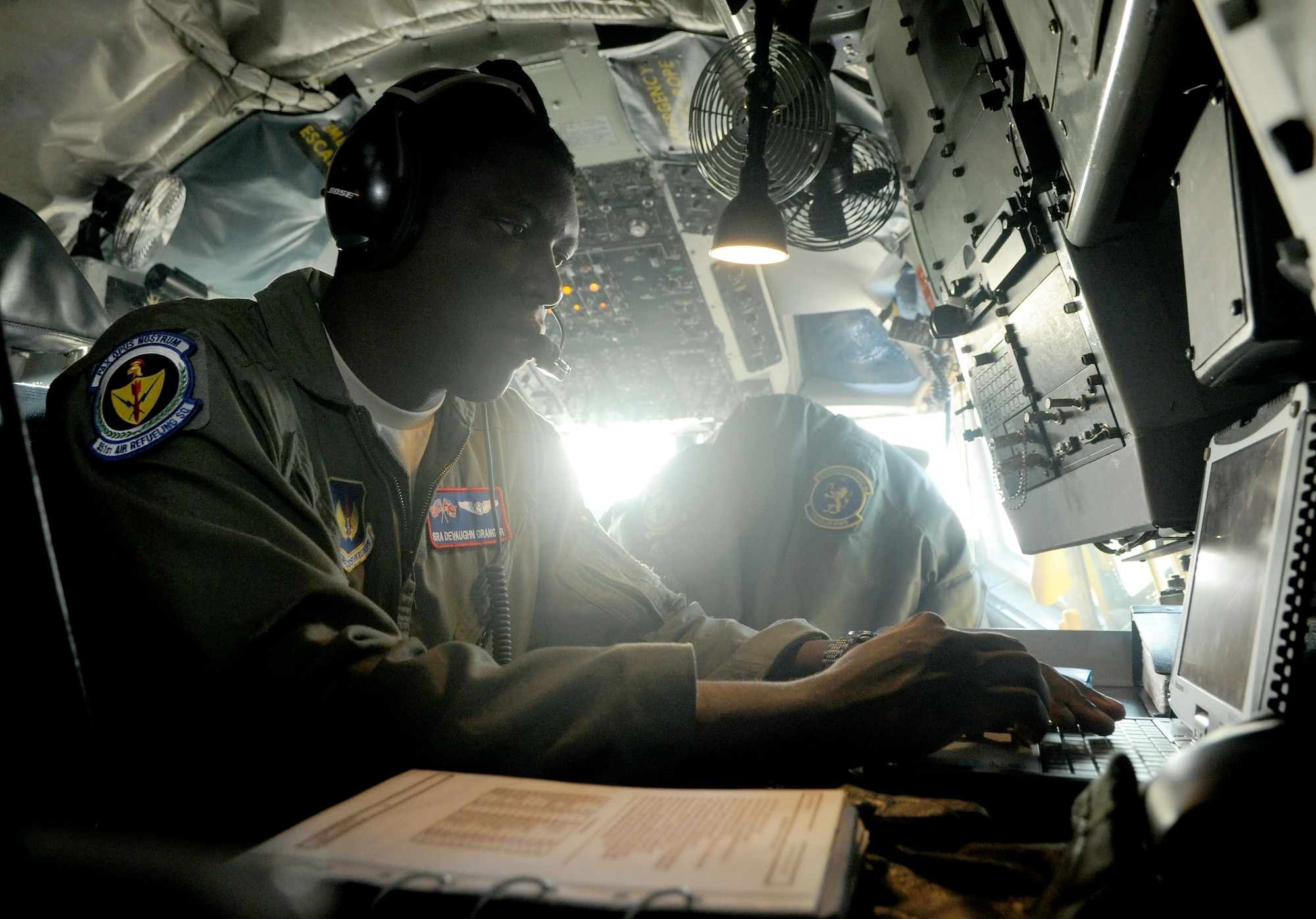 Senior Airman Devaughn Granger, 351st Air Refueling Squadron boom operator from Rome, N.Y., sets up the in-flight computer on a KC-135 Stratotanker April 16, 2014, at RAF Mildenhall, England. The in-flight computer holds publications and forms the aircrew use to prepare the aircraft for a safe flight, as well as troubleshoot problems during and after the flight. (U.S. Air Force photo by Senior Airman Kate Maurer/Released)