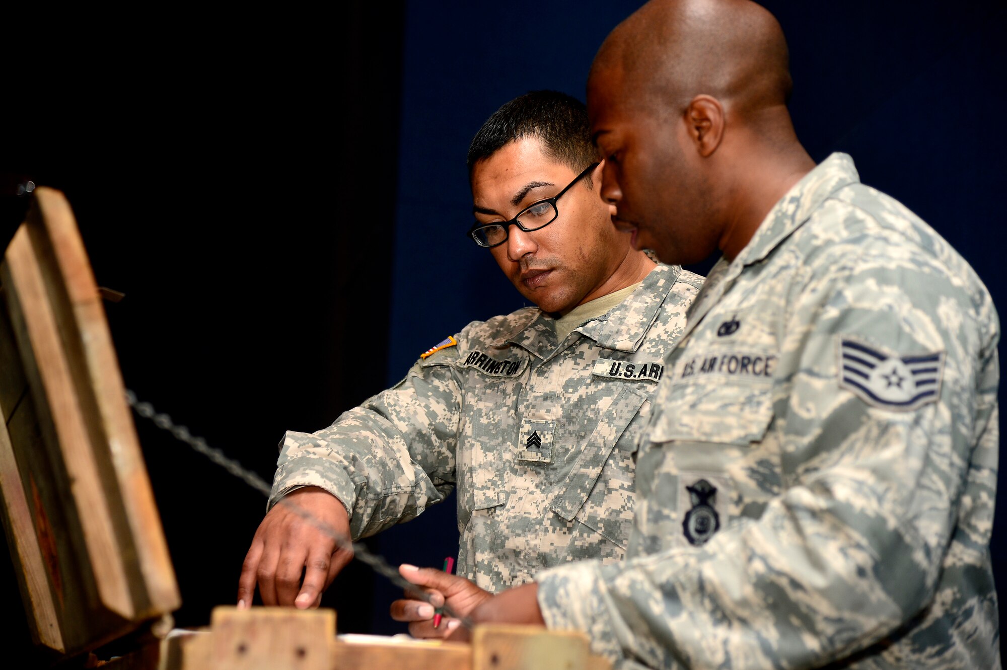 U.S. Army Sgt. Avery Arrington, 221st Military Police Detachment traffic noncommissioned officer in charge, shadows U.S. Air Force Staff Sgt. Dontarie Russ, 633rd Security Forces Squadron military working dog trainer, at Langley Air Force Base, Va., April 15, 2014. Arrington participated in the Security Forces/Military Police Exchange Program, where Soldiers and Airmen trade places to learn about each other’s job. (U.S. Air Force photo by Senior Airman Kayla Newman/Released)