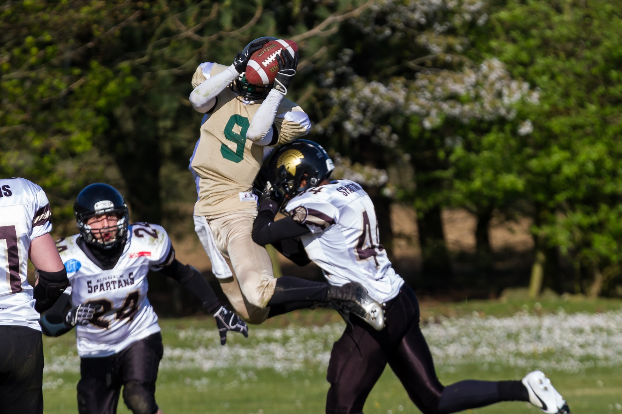Airman 1st Class Trevor T. McBride, 48th Fighter Wing Public Affairs photojournalist and Bury St. Edmunds Saints wide receiver, catches a pass over the Essex Spartans defense at Thurston Rugby Club in Thurston, England, April 13, 2014. The Saints are an integrated American-style football team comprised of U.S. military members from Royal Air Forces Lakenheath and Mildenhall, along with UK citizens. (U.S. Air Force photo by Master Sgt. Jason Passmore/Released)