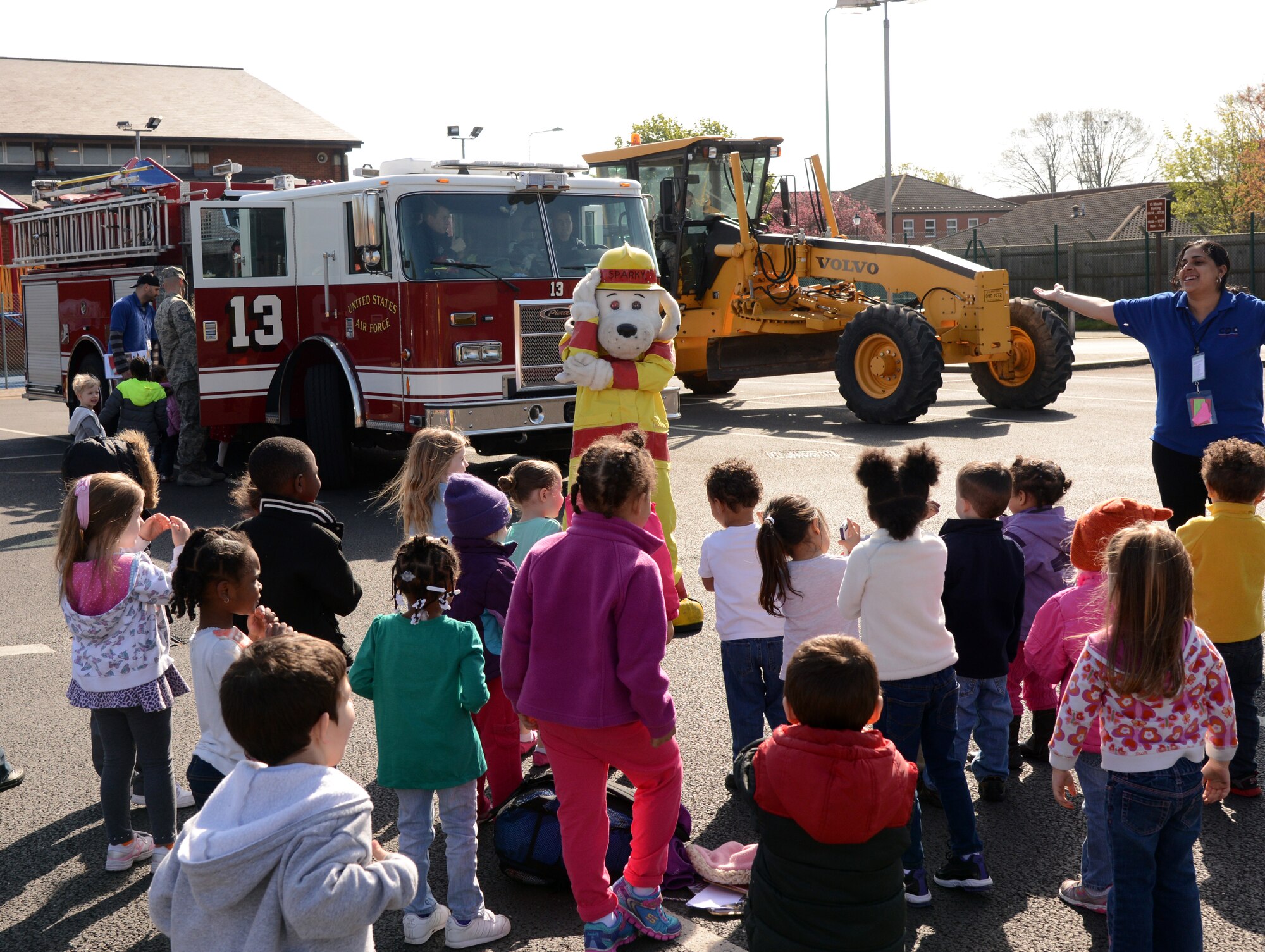 Team Mildenhall children play “Simon Says” with Sparky the Fire Dog, 100th Civil Engineer Squadron Fire Department mascot, during a vehicle expo April 16, 2014, at the Child Development Center on RAF Mildenhall, England. The children explored a 100th CES fire truck and a construction grader. (U.S. Air Force photo by Airman 1st Class Kelsey Waters/Released) 