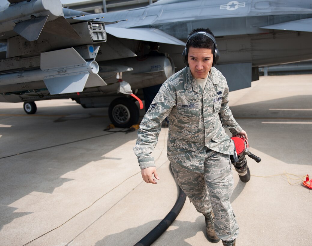 Senior Airman Jacob Rickard, 8th Logistics Readiness Squadron fuels distribution operator, clears a fuel hose during a refueling operation at Kunsan Air Base, Republic of Korea, April 10, 2014. The 8th LRS fuels management flight keeps the Wolf Pack running by delivering fuel when and where it is needed. (U.S. Air Force photo by Staff Sgt. Clayton Lenhardt/Released)