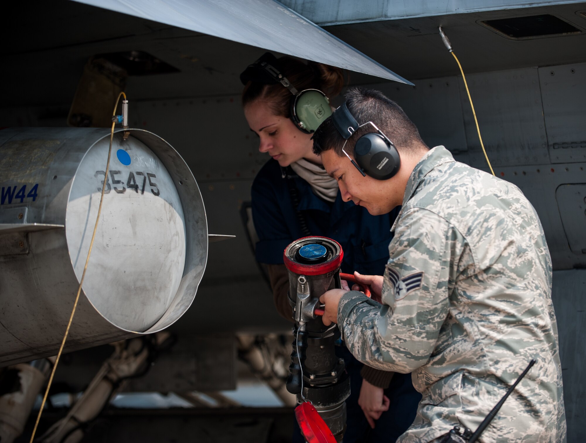 Staff Sgt. Jennipher Jackson, 8th Aircraft Maintenance Squadron engine specialist, left, and Senior Airman Jacob Rickard, 8th Logistics Readiness Squadron fuels distribution operator, detach a fuel hose during refueling at Kunsan Air Base, Republic of Korea, April 10, 2014. The 8th LRS fuels management flight keeps the Wolf Pack running by delivering fuel when and where it is needed. (U.S. Air Force photo by Staff Sgt. Clayton Lenhardt/Released)