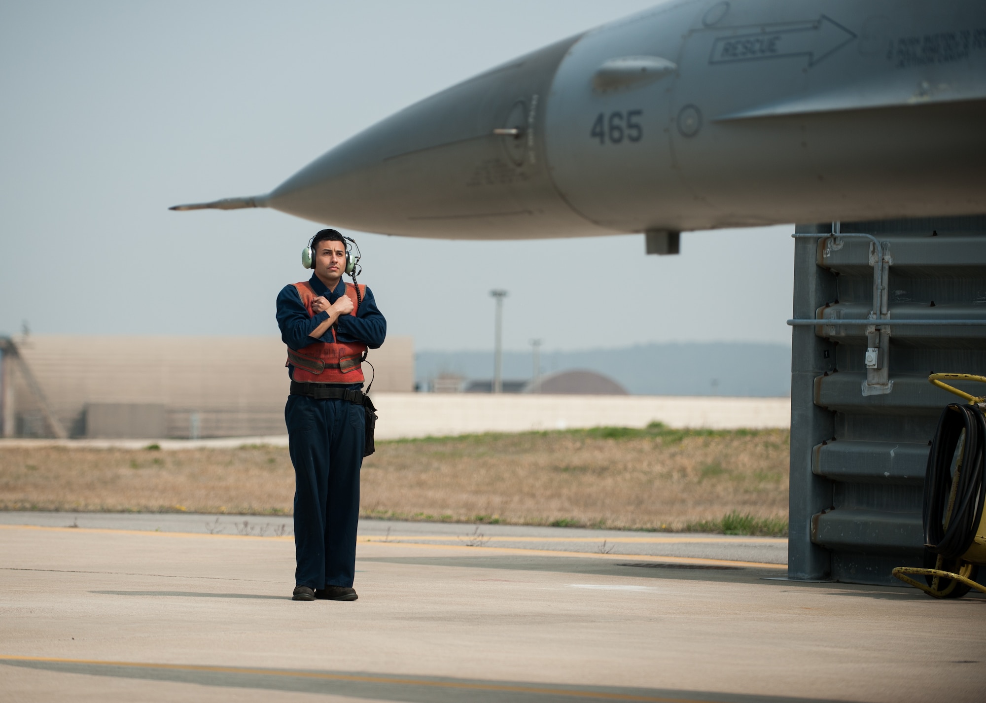 Senior Airman Jorge Zaragoza, 8th Aircraft Maintenance Squadron dedicated crew chief, directs an F-16 Fighting Falcon before a hot pit refueling at Kunsan Air Base, Republic of Korea, April 10, 2014. Refueling the aircraft while the engine is running allows the Wolf Pack to quickly get jets back in the air. (U.S. Air Force photo by Staff Sgt. Clayton Lenhardt/Released)