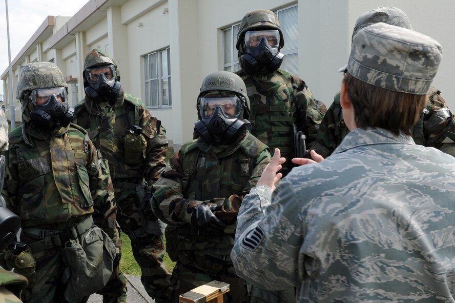 U.S. Air Force Tech. Sgt. Kristen Bockman, 18th Civil Engineer Squadron NCO in charge of emergency management plans and operations, teaches Airmen the procedure for reporting the presence of substances identifiable by M8 chemical detection paper during Chemical, Biological, Radiological, Nuclear and Explosives training on Kadena Air Base, Japan, April 14, 2014. CBRNE training is intended to prepare Airmen for the possibility of a chemical, biological, radiological or nuclear attack, and teaches them the proper procedures for identifying and reporting any hazardous materials and or unexploded ordinance. (U.S. Air Force photo by Airman 1st Class Zade C. Vadnais)