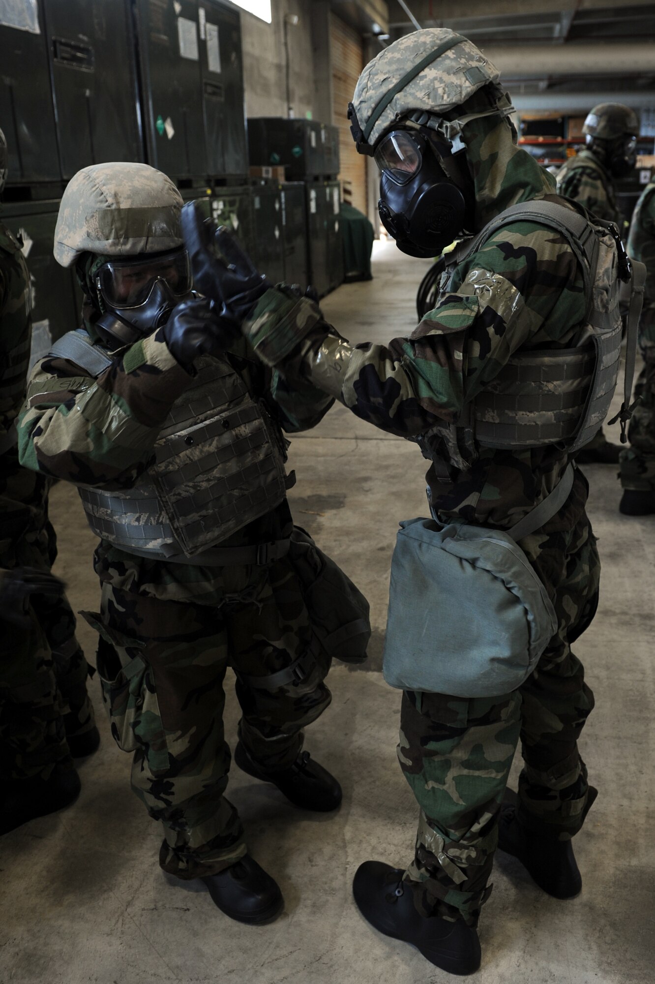 U.S. Air Force Tech. Sgt. Lauren Berger, 18th Security Forces Squadron security forces instructor, performs a buddy check on Senior Airman Jon Kroeger, 18th SFS response force leader, to ensure he is wearing his Mission Oriented Protective Posture gear properly during Chemical, Biological, Radiological, Nuclear and Explosives training on Kadena Air Base, Japan, April 14, 2014. Buddy checks are designed to ensure Airmen have properly assembled their MOPP gear, since it can be hard to do a self-check with limited vision and range of motion. (U.S. Air Force photo by Airman 1st Class Zade C. Vadnais)