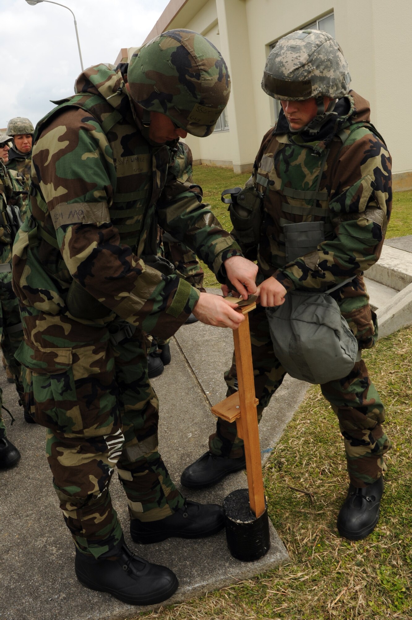 U.S. Air Force Staff Sgt. Guy Warren, 18th Equipment Maintenance Squadron repair and reclamation technician, and Senior Airman James Hunt, 18th Logistics Readiness Squadron fuels facilities apprentice, examine a mock Post-Attack Reconnaissance stand during Chemical, Biological, Radiological, Nuclear and Explosives training on Kadena Air Base, Japan, April 14, 2014. CBRNE training is intended to prepare Airmen for the possibility of a chemical, biological, radiological or nuclear attack, and PAR stand training teaches them how to identify and report the presence of those materials. (U.S. Air Force photo by Airman 1st Class Zade C. Vadnais)