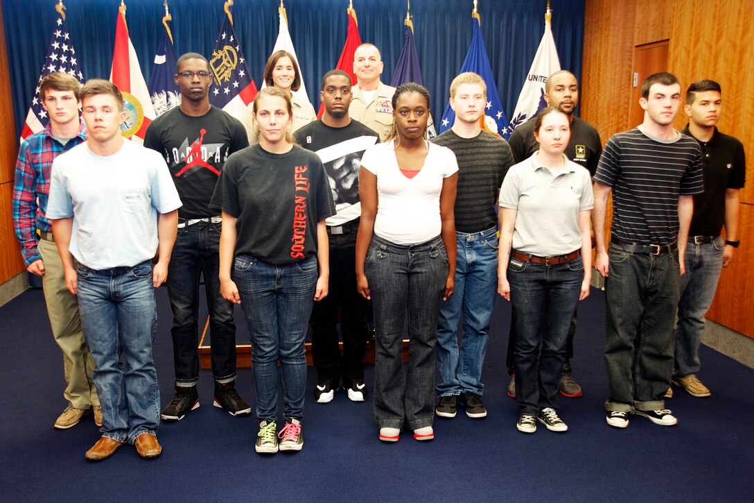Marine Corps Sgt. Maj. Bryan B. Battaglia, back center, senior enlisted advisor to the chairman of the Joint Chiefs of Staff, poses for a photograph with newly enlisted service members at the Military Entrance Processing Station in Jacksonville, Fla., April 16, 2014.