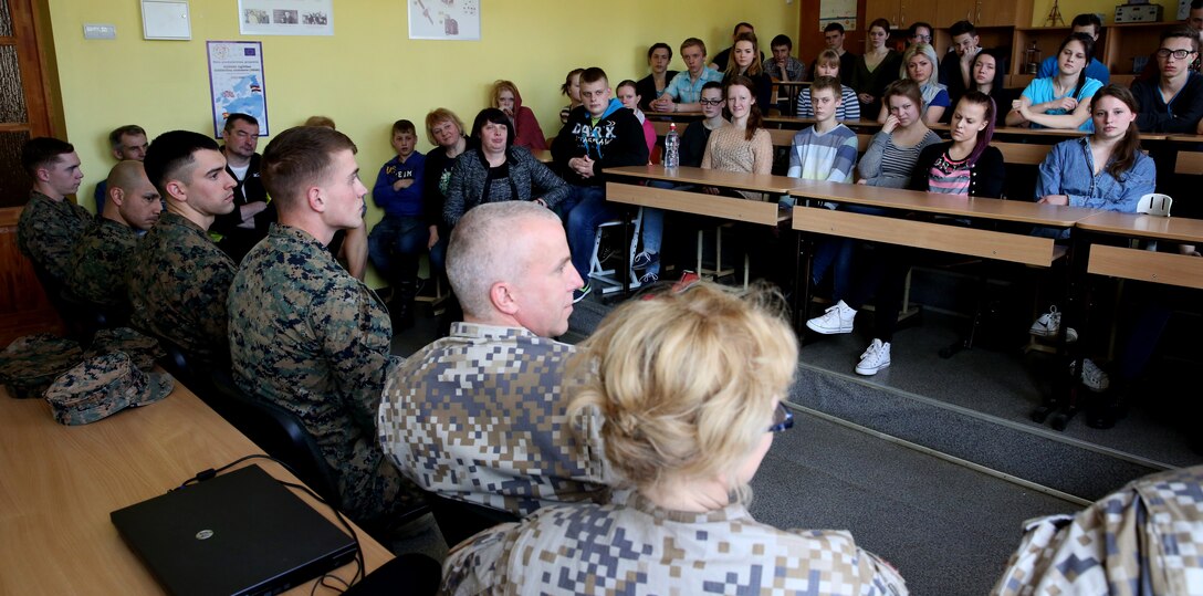 United States Marines, Latvian soldiers and an Estonian service member take questions from a class at Lejasciems Secondary School in Lejasciems, Latvia, April 9, 2014. The service members were invited to the school during Summer Shield to speak with children at the school about their experiences in the military, and to answer any other questions they had. This is the 11th iteration of the Summer Shield exercise, a joint staff planning and combined arms live fire maneuver event designed to enhance the Latvian Land Force’s capacity and capability to integrate fires and maneuver at the battalion and brigade level as well as increase partner capacity, promote regional stability, and continue to develop Latvian, Lithuanian, Estonian and U.S. interoperability. (Official Marine Corps photo by Lance Cpl. Scott W. Whiting, BSRF PAO/ Released)