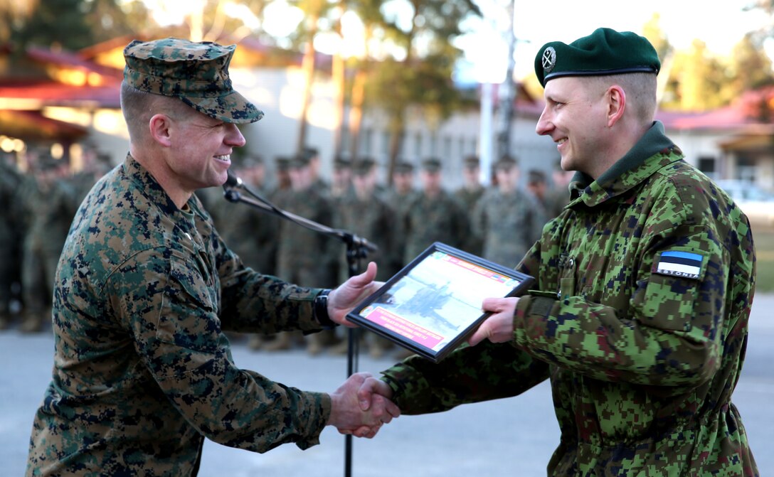 U.S. Marine Lt. Col. Trevor Hall, battalion commander of Black Sea Rotational Force 14 from 3rd Battalion, 8th Marine Regiment, 2nd Marine Division, presents a gift to Estonian Lt. Col. Kaarel Maesalu, the battalion commander of the Estonian Defense Forces Artillery Battalion, during the closing ceremony for exercise Summer Shield aboard Camp Adazi, Latvia, April 16, 2014. This is the 11th iteration of the Summer Shield exercise, a joint staff planning and live-fire maneuver event designed to enhance the NATO force’s capacity and capability to integrate combined arms and maneuver at the battalion and brigade level. It also increases partner capacity, promotes regional stability, and enhances Latvian, Lithuanian, Estonian, and U.S. interoperability as NATO allies. (Official Marine Corps photo by Lance Cpl. Scott W. Whiting, BSRF PAO/ Released)