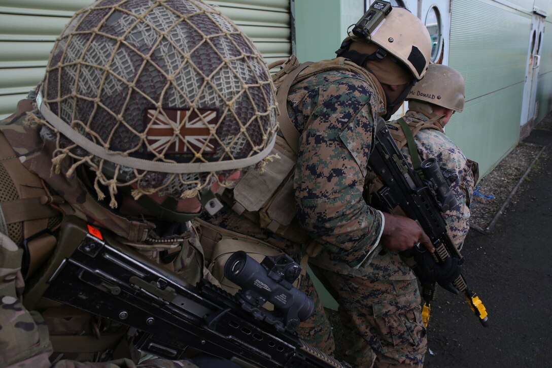 Marines with 4th Air Naval Gunfire Liaison Company, Force Headquarters Group, Marine Forces Reserve practice close-quarters-combat tactics alongside their British counterparts with 7th Paratroopers Royal Horse Artillery, 16th Air Assault Brigade, April 9, during exercise Joint Warrior 2014. ANGLICO units normally deploy in small supporting arms liaison teams, using their specialized call-for-fire techniques to combine different air, naval and artillery platforms from any NATO unit.