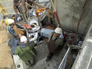 Contractor workers at Little Goose Dam install the new gudgeon arm assembly on the top of the navigation lock’s downstream south gate leaf.
