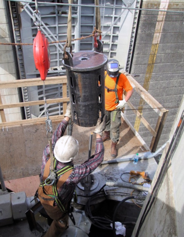 Contractor workers at Little Goose Dam remove components of the cracked gudgeon arm assembly on top of the navigation lock’s south gate leaf. The 50-year-old pins required use of an air-arc cutter to remove them.