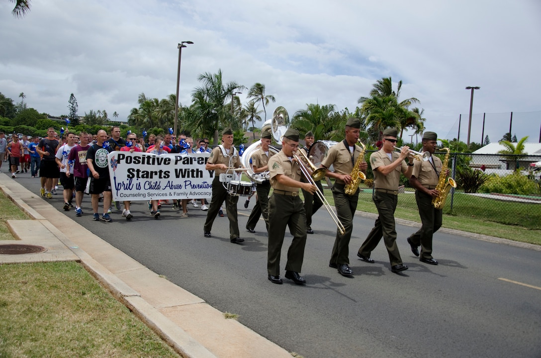 Participants, led by the U.S. Marine Corps Forces, Pacific Band’s party band, leave Kaneohe Klipper Golf Course and begin the Pinwheels for Prevention Walk, April 11, 2014. (U.S. Marine Corps photo by Kristen Wong)