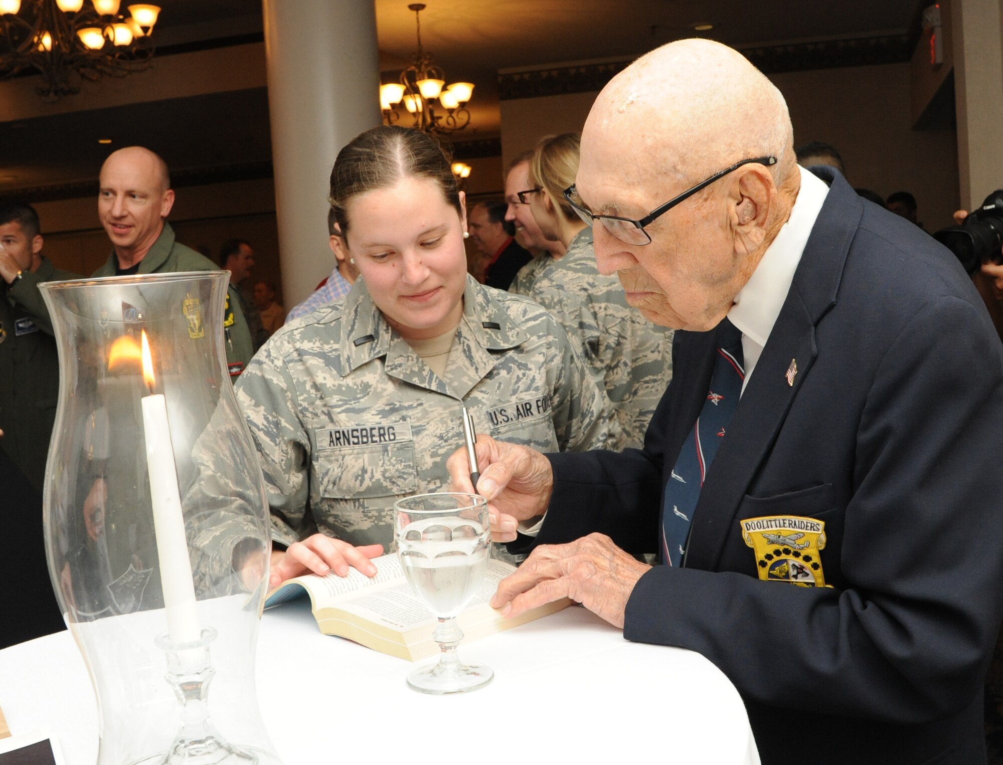 Retired Lt. Col. Richard Cole, co-pilot of Aircraft No. 1 from the Doolittle Tokyo Raid, signs an autograph for 1st Lt. Emily Arnsberg, from Joint Base San Antonio-Randolph, during the 72nd Doolittle Tokyo Raiders anniversary celebration event April 18 at the JBSA-Randolph Parr Club.  Cole is one of four remaining survivors from the Doolittle Tokyo Raid of 1942.  (U.S. Air Force photo/Melissa Peterson)