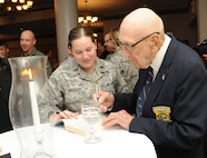 Retired Lt. Col. Richard Cole, co-pilot of Aircraft No. 1 from the Doolittle Tokyo Raid, signs an autograph for 1st Lt. Emily Arnsberg, from Joint Base San Antonio-Randolph, during the 72nd Doolittle Tokyo Raiders anniversary celebration event April 18 at the JBSA-Randolph Parr Club.  Cole is one of four remaining survivors from the Doolittle Tokyo Raid of 1942.  (U.S. Air Force photo/Melissa Peterson)