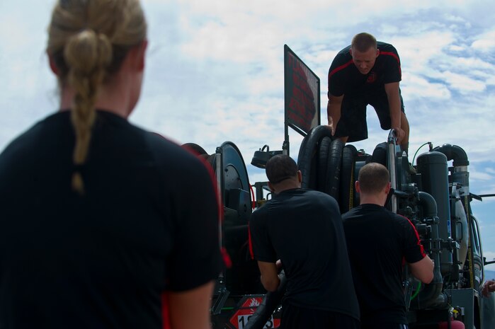 Team "99th Contracting Squadron" reel in a fuel hose for the 99th Logistics Readiness Squadron Life of a Warrior Challenge April 11, 2014, at Nellis Air Force Base, Nev. The 99th Contracting Squadron was one of 19 teams to participate in the 99th LRS Life of a Warrior Challenge. (U.S. Air Force photo by Airman 1st Class Jake Carter)