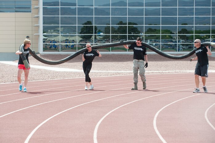 Team "Mission Support Group" run around the track with a fuel hose during the 99th Logistics Readiness Squadron Life of a Warrior Challenge April 11, 2014, at Nellis Air Force Base, Nev. The 99th MSG was one of 19 teams to participate in the Life of a Warrior Challenge. (U.S. Air Force photo by Airman 1st Class Jake Carter)