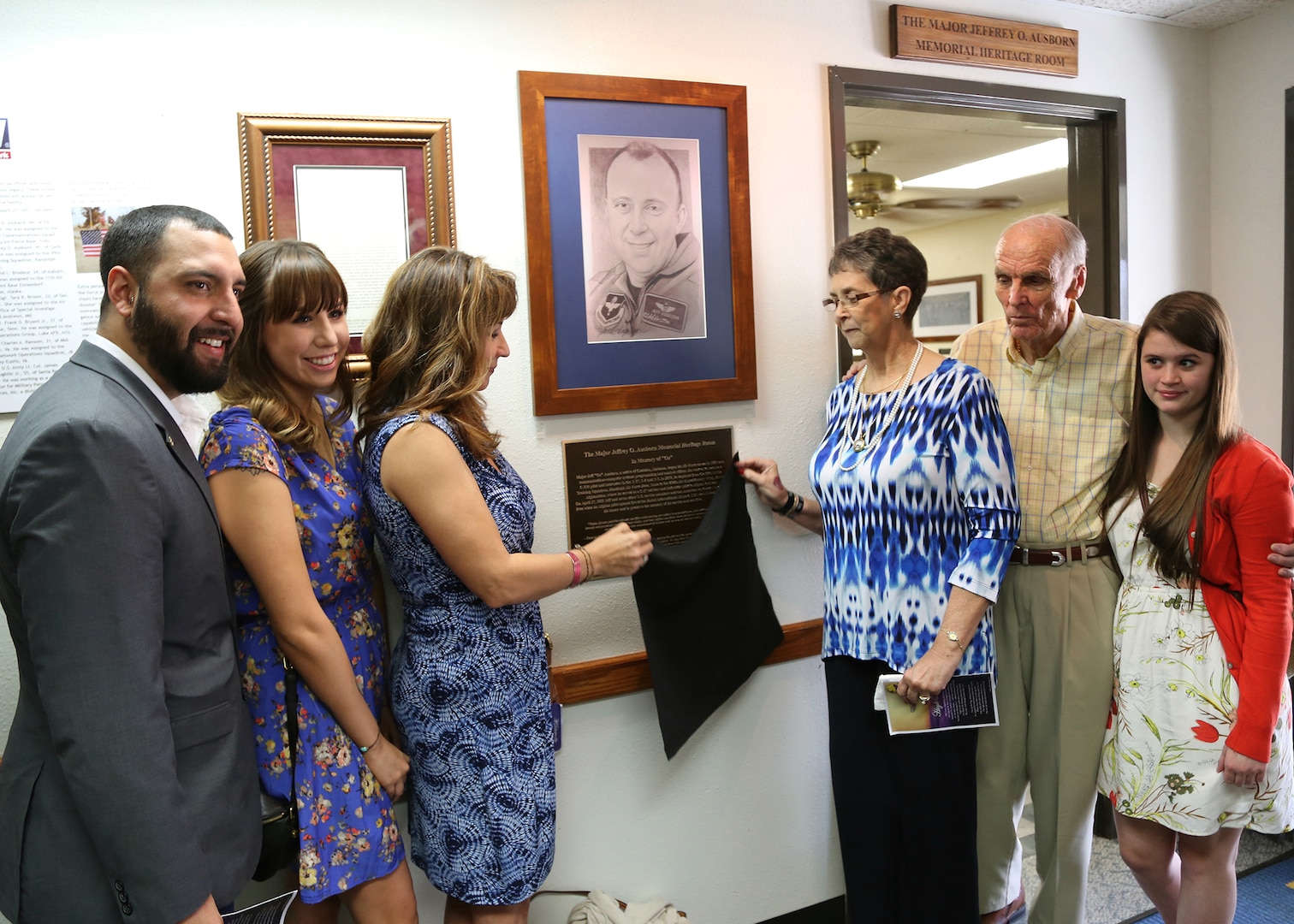 Family members of Maj. Jeff Ausborn unveil the Maj. Jeffrey Ausborn Memorial Heritage Room plaque April 18 at the 99th Flying Training Squadron at Joint Base San Antonio-Randolph.  Pictured (from left) are Mitchell Maloy, step-son, Summer Maloy, step-daughter, Suzanna Ausborn, widow, Faye and Clifford Ausborn, parents, and Emily Ausborn, daughter. Ausborn, 41, was deployed from JBSA-Randolph and killed April 27, 2011, in Kabul, Afghanistan, when a shooter opened fire at the Kabul International Airport killing eight Airmen and one American contractor.  Ausborn was deployed to the 438th Air Expeditionary Wing where he served as a C-27 instructor pilot to new Afghan pilots. (U.S. Air Force photo by Melissa Peterson)
