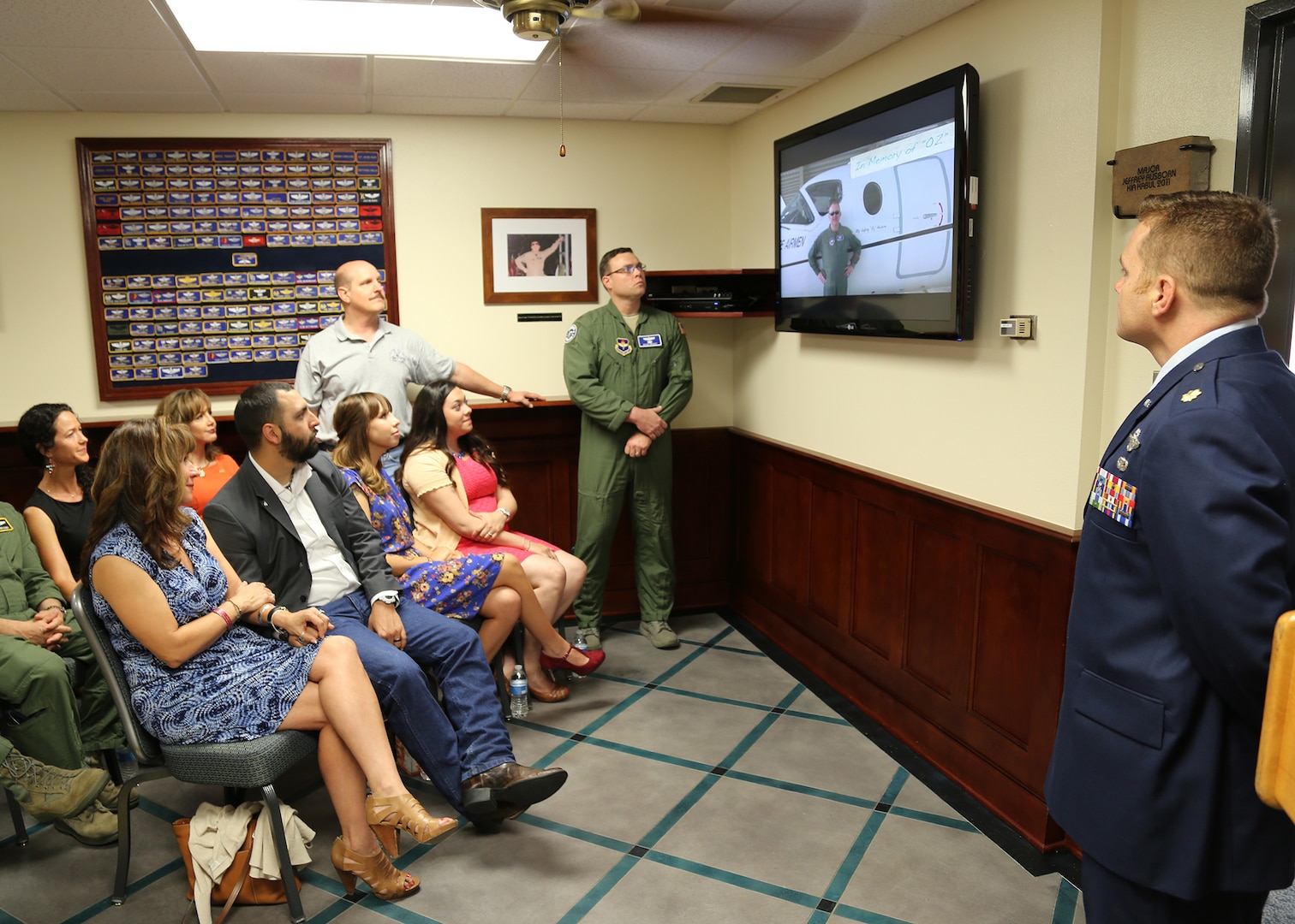 Maj. Jeff Ausborn’s family and friends watch a slide show in the Ausborn Memorial Heritage Room during a dedication ceremony April 18 at the 99th Flying Training Squadron at Joint Base San Antonio-Randolph.  Ausborn was deployed from JBSA-Randolph and killed April 27, 2011, in Kabul, Afghanistan, when a shooter opened fire at the Kabul International Airport killing eight Airmen and one American contractor. (U.S. Air Force photo by Melissa Peterson)