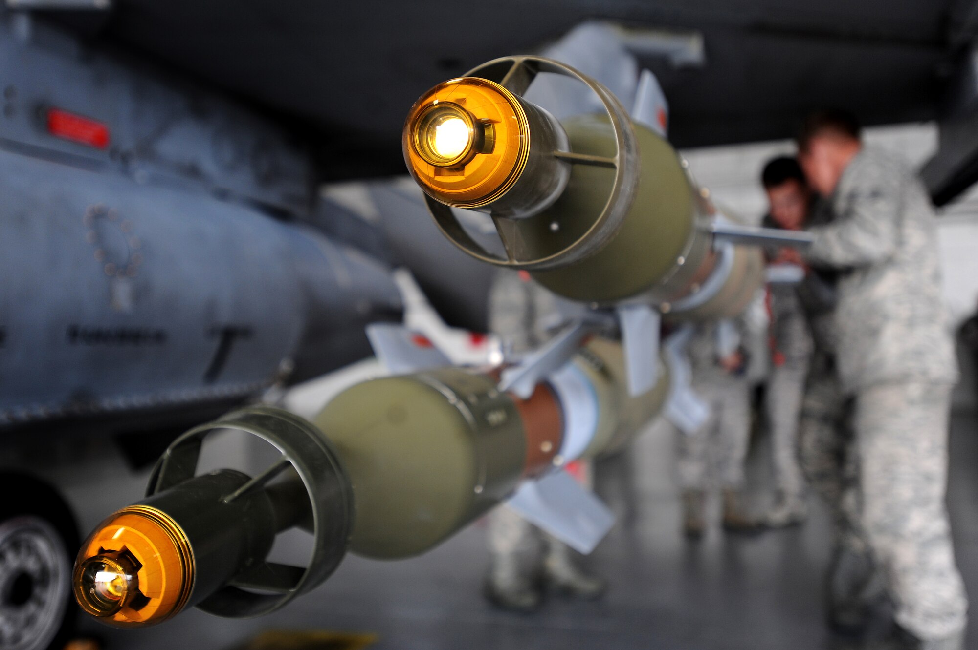 Munitions are inspected and secured to an F-16CJ Fighting Falcon by U.S. Air Force weapons load crew members assigned to the 20th Maintenance Group during a load crew of the year competition, April 18, 2014, Shaw Air Force Base, S.C. The 20th Fighter Wing weapons standardization unit held the annual competition which brings together weapons load crew members from all three fighter squadrons at Shaw to compete against each other. The competition showcases Airmen’s skills and job knowledge while also building camaraderie amongst the units. (U.S. Air Force photo by Staff Sgt. Kenny Holston/Released)