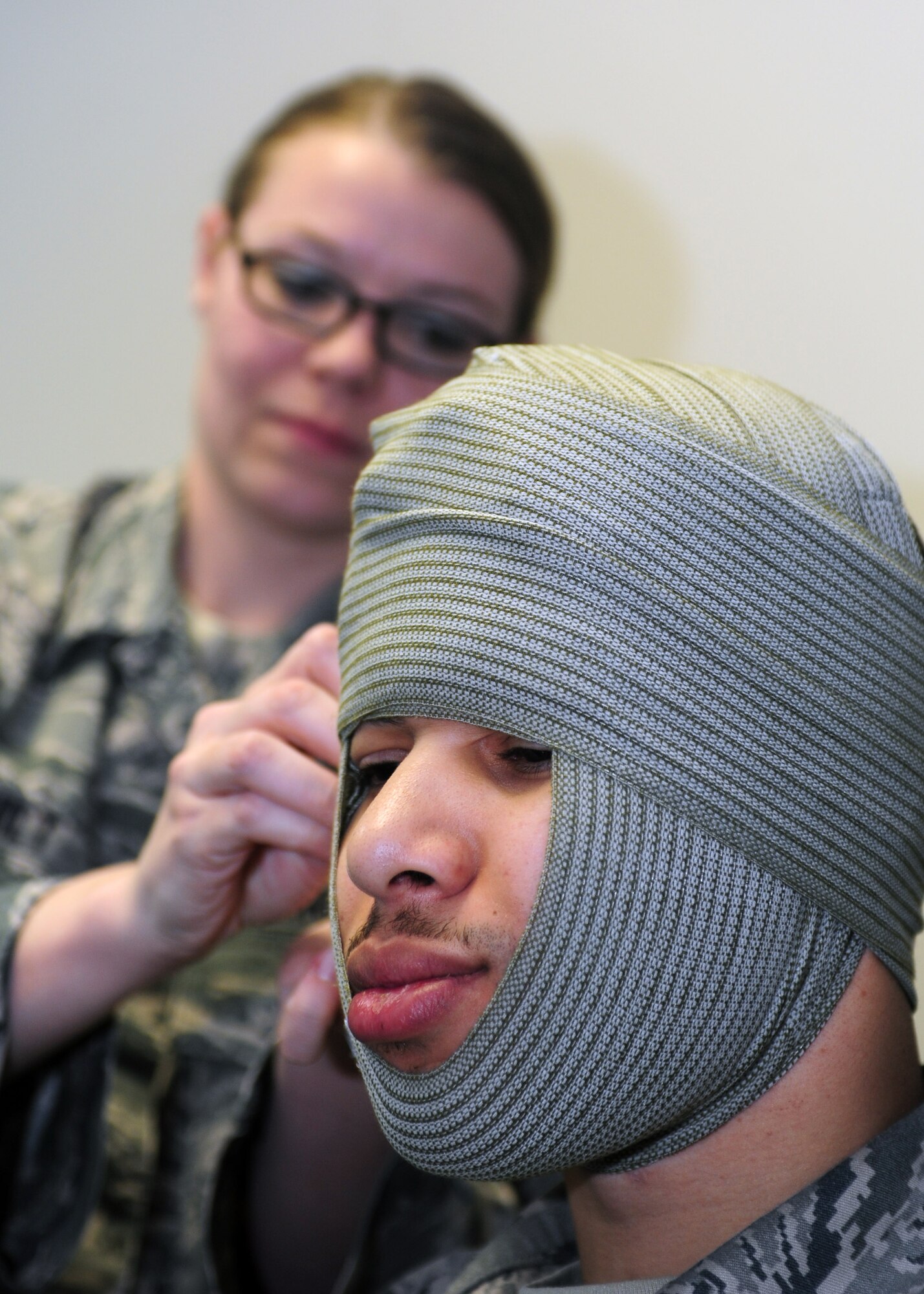 Staff Sgt. Brittney Demilt, 92nd Comptroller Squadron financial analyst, practices wrapping a bandage around Staff Sgt. Dahlian Jackson’s head during a hands on self-aid and buddy care class at Fairchild Air Force Base, Wash, April 17, 2014. A few topics covered during the SABC course included airway management, recognition and control of bleeding, bandaging, and treatment of burn injuries. Jackson is one of the SABC instructors on Fairchild. (U.S. Air Force photo by Senior Airman Taylor Curry/Released)