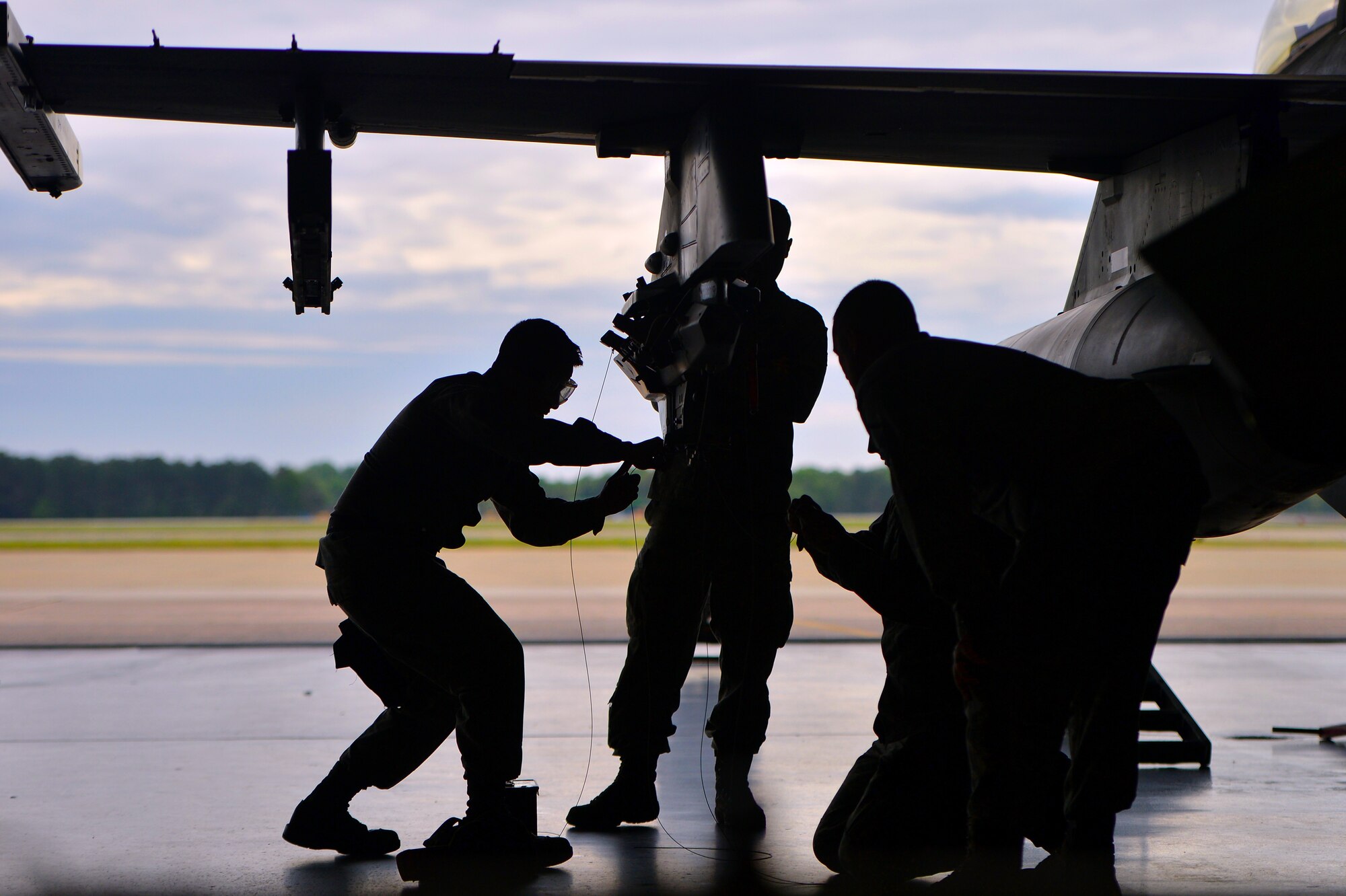 U.S. Air Force weapons load crew members assigned to the 20th Maintenance Group work together to quickly load munitions onto an F-16CJ Fighting Falcon during a load crew of the year competition, April 18, 2014, Shaw Air Force Base, S.C. The 20th Fighter Wing weapons standardization unit held the annual competition which brings together weapons load crew members from all three fighter squadrons at Shaw to compete against each other. The competition showcases Airmen’s skills and job knowledge while also building camaraderie amongst the units. (U.S. Air Force photo by Staff Sgt. Kenny Holston/Released)