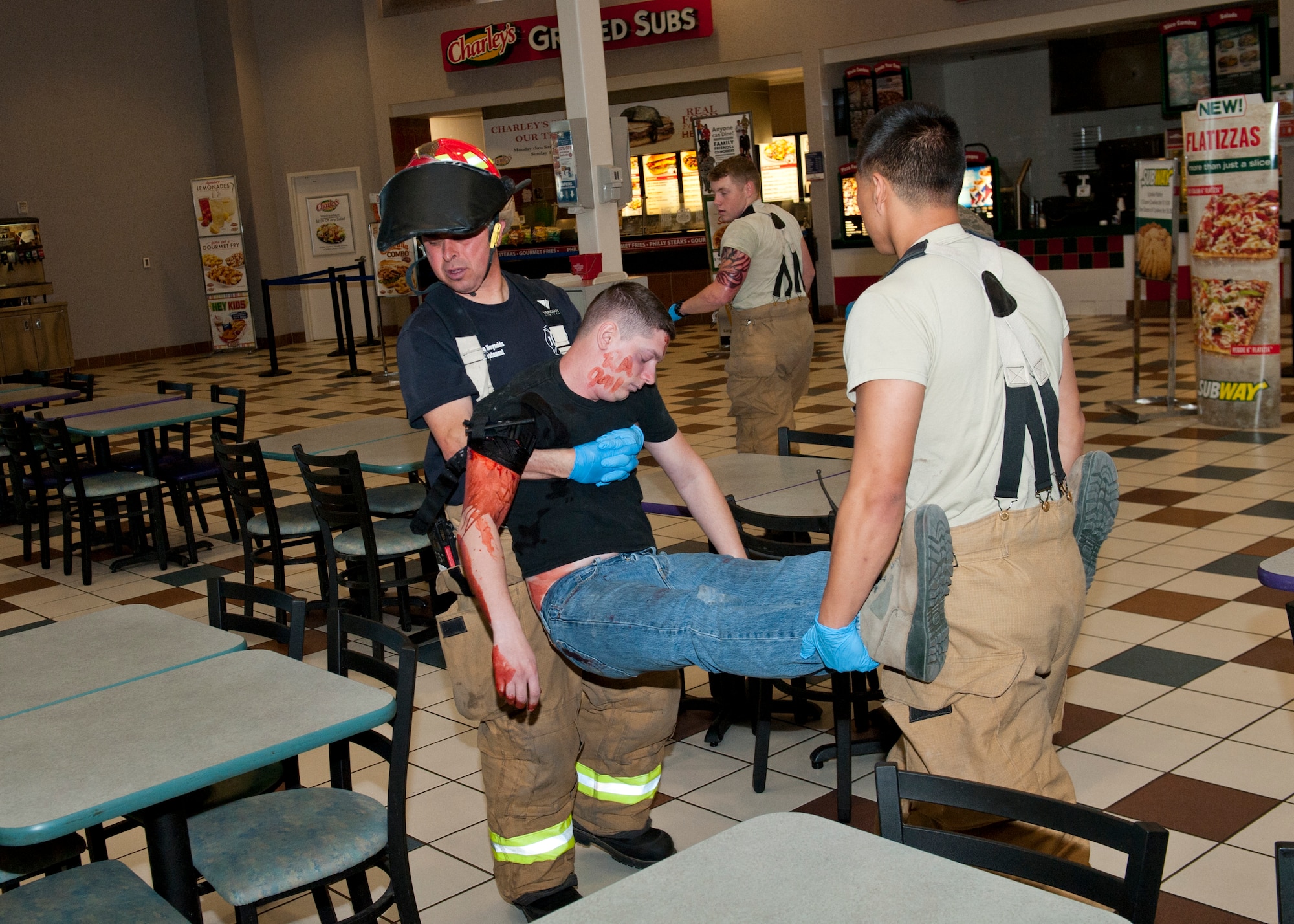 49th Civil Engineer Squadron fire protection flight members help evacuate a victim during the active shooter exercise inside the Base Exchange at Holloman Air Force Base, N.M., April 17. Holloman maintains readiness to respond to emergencies such as active shooters by conducting training exercises multiple times a year.  The 49th Security Forces Squadron and the 49th Civil Engineer Squadron were able to quickly respond to the exercise scenario, neutralize the threats and evacuate the victims. (U.S. Air Force photo by Senior Airman Daniel Liddicoet/Released)
