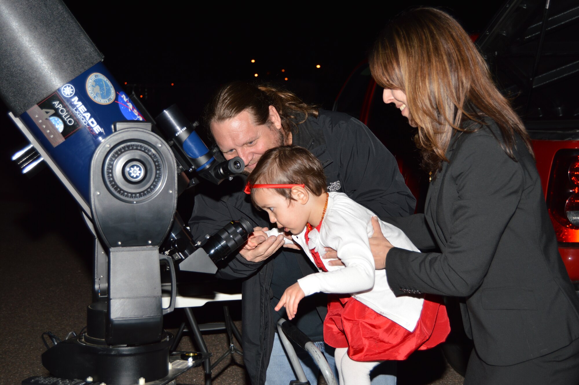 Adrienn Loughmiller helps her 3-year-old daughter, Emma, look through a telescope at the Falcon Club April 10. The Academy hosted a Fort Carson-sponsored event to commemorate service members killed in the line of duty by dedicating a star in their honor.  (Courtesy photo)