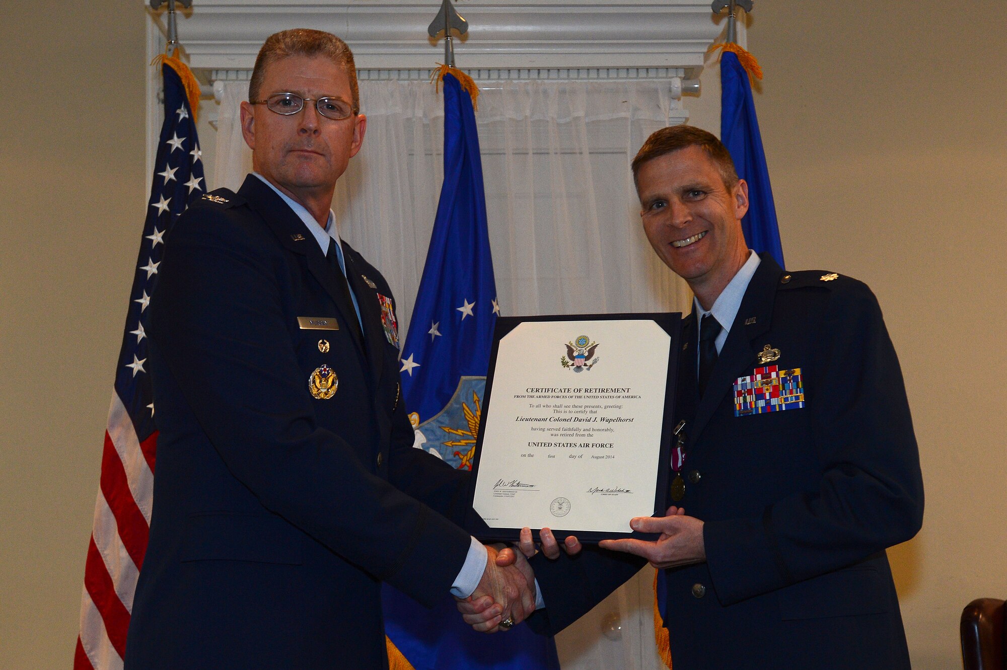 U.S. Air Force Col. Scott Murray, U.S. Air Forces Central Command director of intelligence, presents Lt. Col. Dave Wapelhorst, AFCENT chief of staff assistant, his certificate of retirement at the Carolina Skies Club, Shaw Air Force Base, S.C., April 18, 2014. Wapelhorst’s family, friends and co-workers attended the ceremony where he thanked everybody for their continual support as well as thanked his parents for the motivation early on in his childhood. (U.S Air Force photo by Airman 1st Class Jensen Stidham/Released)