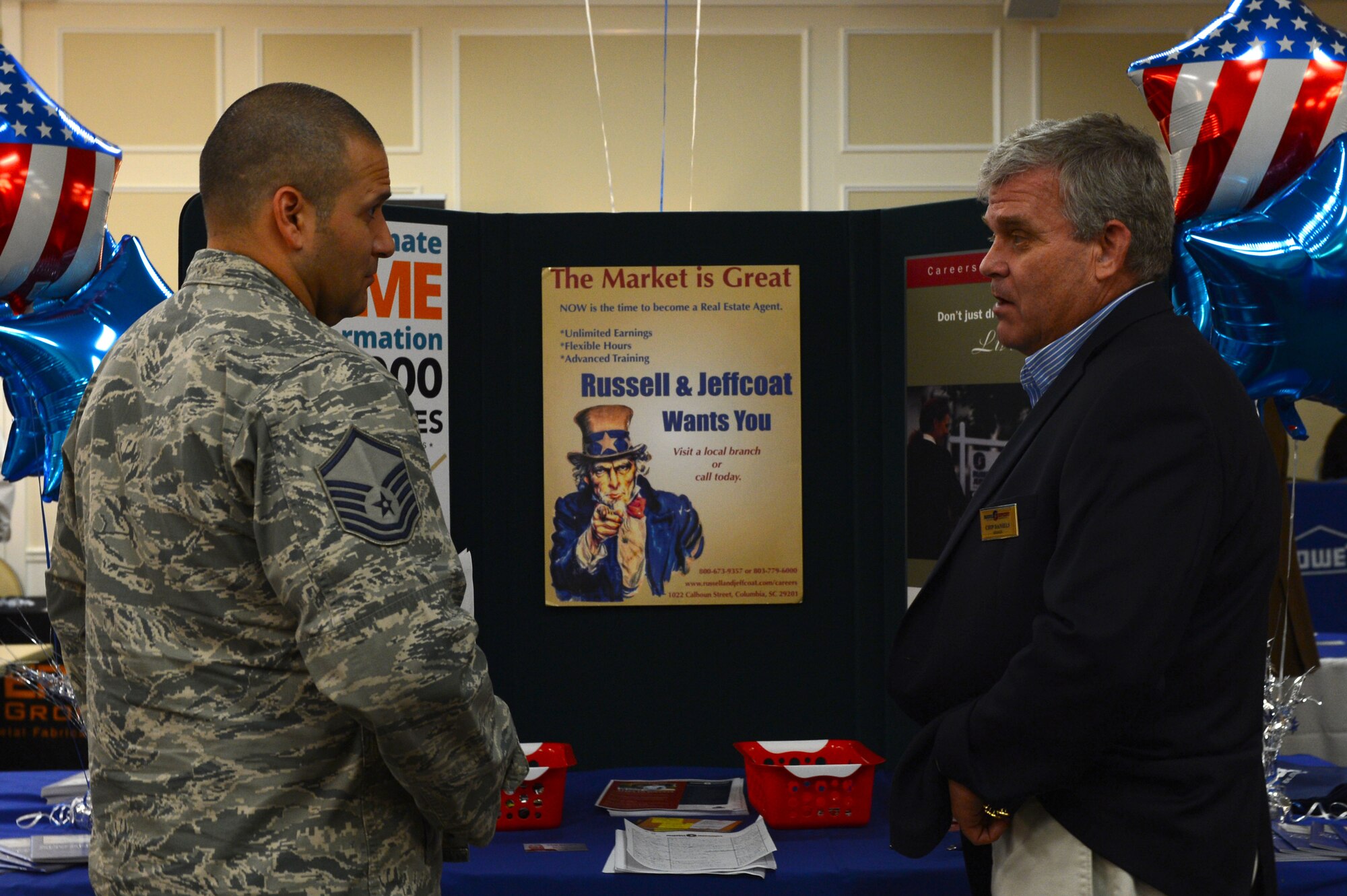 U.S. Air Force Master Sgt. Joel Luera, Air Forces Central Command personnel readiness superintendent, speaks with a real estate representative during a job fair at the Carolina Skies Club, Shaw Air Force Base, S.C., April 17, 2014. Luera, who is retiring in October, came to the fair to learn about career opportunities that could benefit him once he has been separated from the armed forces. (U.S. Air Force photo by Airman 1st Class Jensen Stidham/Released)