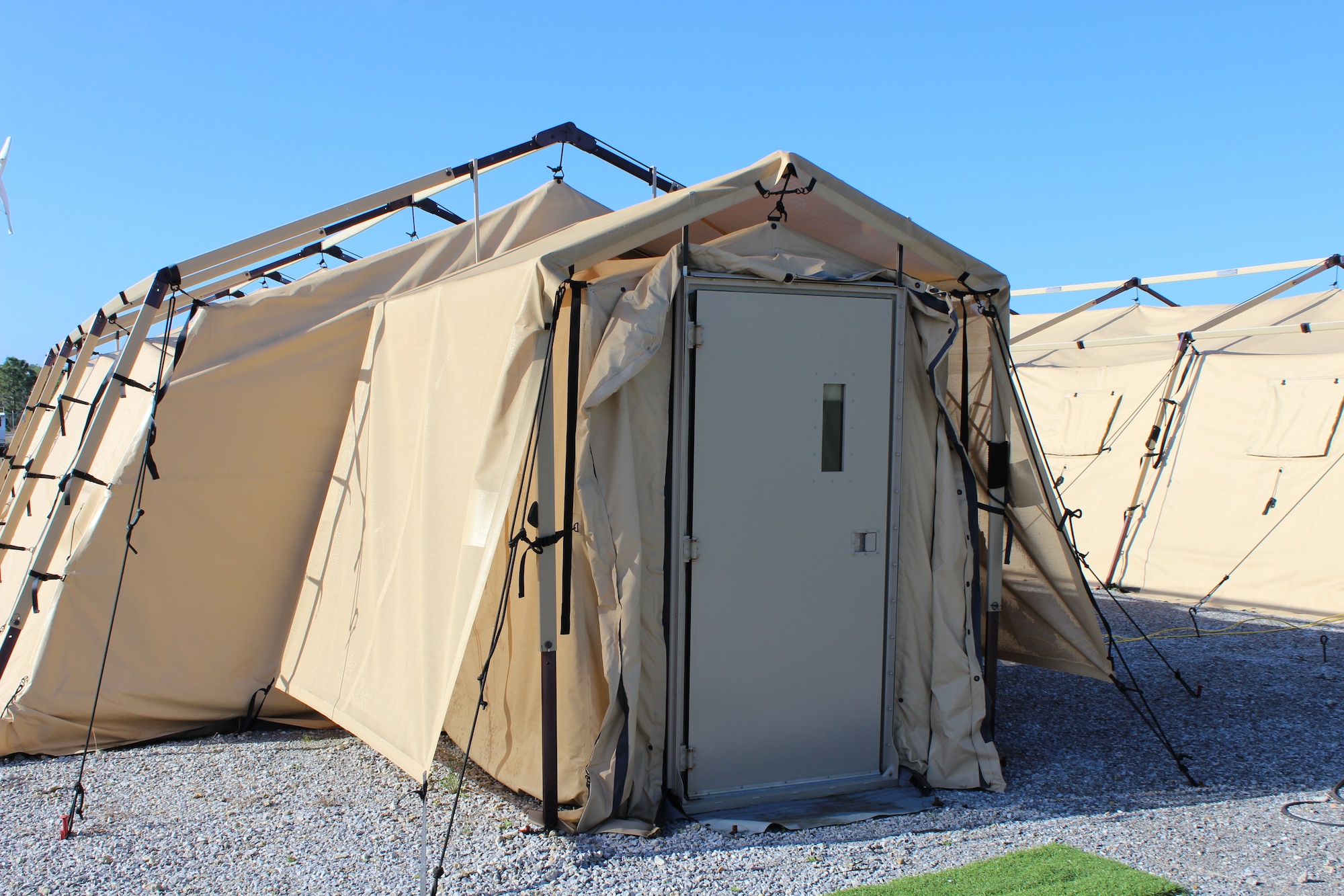 Shelters such as this one on display at Tyndall Air Force Base, Fla., are used to house Airmen in contingency locations. Features designed to reduce energy use, such as a vestibule, hard door and shade fly, can reduce energy consumption as much as 63 percent, based on recent tests in Southwest Asia. (U.S. Air Force photo/Jennifer McCabe)