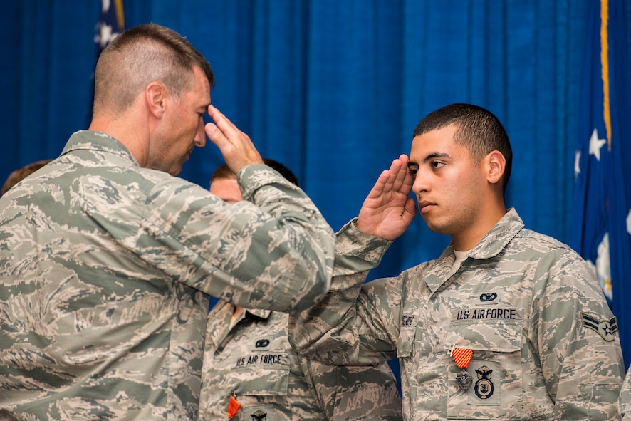 U.S Air Force Airman 1st Class Kyle Rosenberg, right, 822d Base Defense Group fire team member, salutes Col. Paul Kasuda, 820th Base Defense Group commander, after being presented an award at Moody Air Force Base, Ga., April 17, 2014. Rosenberg and his team, Reaper Seven, were awarded the Combat Action Medal for their participation in direct combat actions near Bagram Airfield, Afghanistan. (U.S. Air Force photo by Airman 1st Class Ryan Callaghan/Released)