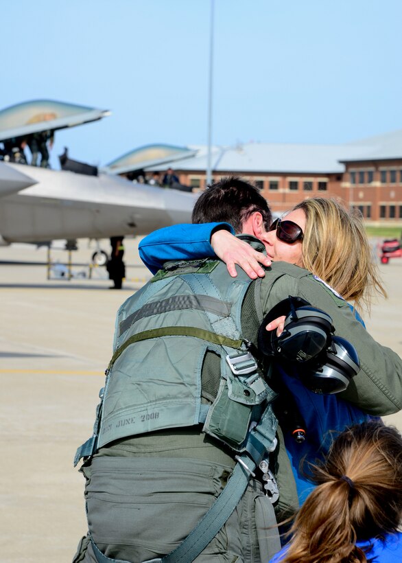 Suzanne McGinn greets her husband, U.S. Air Force Capt. Marcus McGinn, 94th Fighter Squadron F-22 Raptor pilot, during a deployment homecoming at Langley Air Force Base, Va., April 17, 2014. The F-22’s were assigned to U.S. Pacific Command as part of the unit's Theater Security Package rotation at Kadena Air Base, Japan. (U.S. Air Force photo by Staff Sgt. Antoinette Gibson/Released)