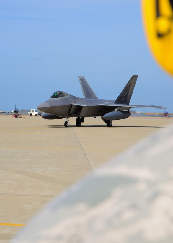 A 94th Fighter Squadron crew chief watches as an F-22 Raptor taxis at Langley Air Force Base, Va., April 17, 2014. The F-22s were assigned to U.S. Pacific Command as part of the unit's Theater Security Package rotation at Kadena Air Base, Japan. (U.S. Air Force photo by Staff Sgt. Antoinette Gibson/Released)