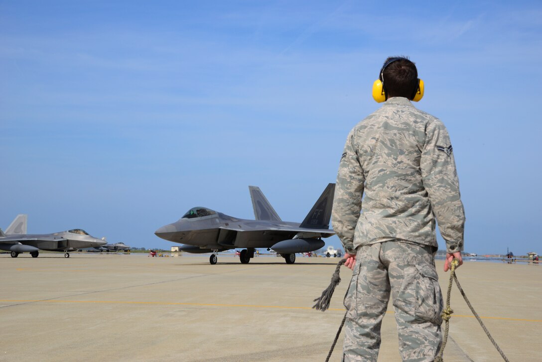 A 94th Fighter Squadron crew chief marshals in a F-22 Raptor at Langley Air Force Base, Va., April 17, 2014. The 94th FS deployed for nearly four-months to Kadena Air Base, Japan, to demonstrate the continued U.S. commitment to maintain peace throughout the Western Pacific. (U.S. Air Force photo by Staff Sgt. Antoinette Gibson/Released)