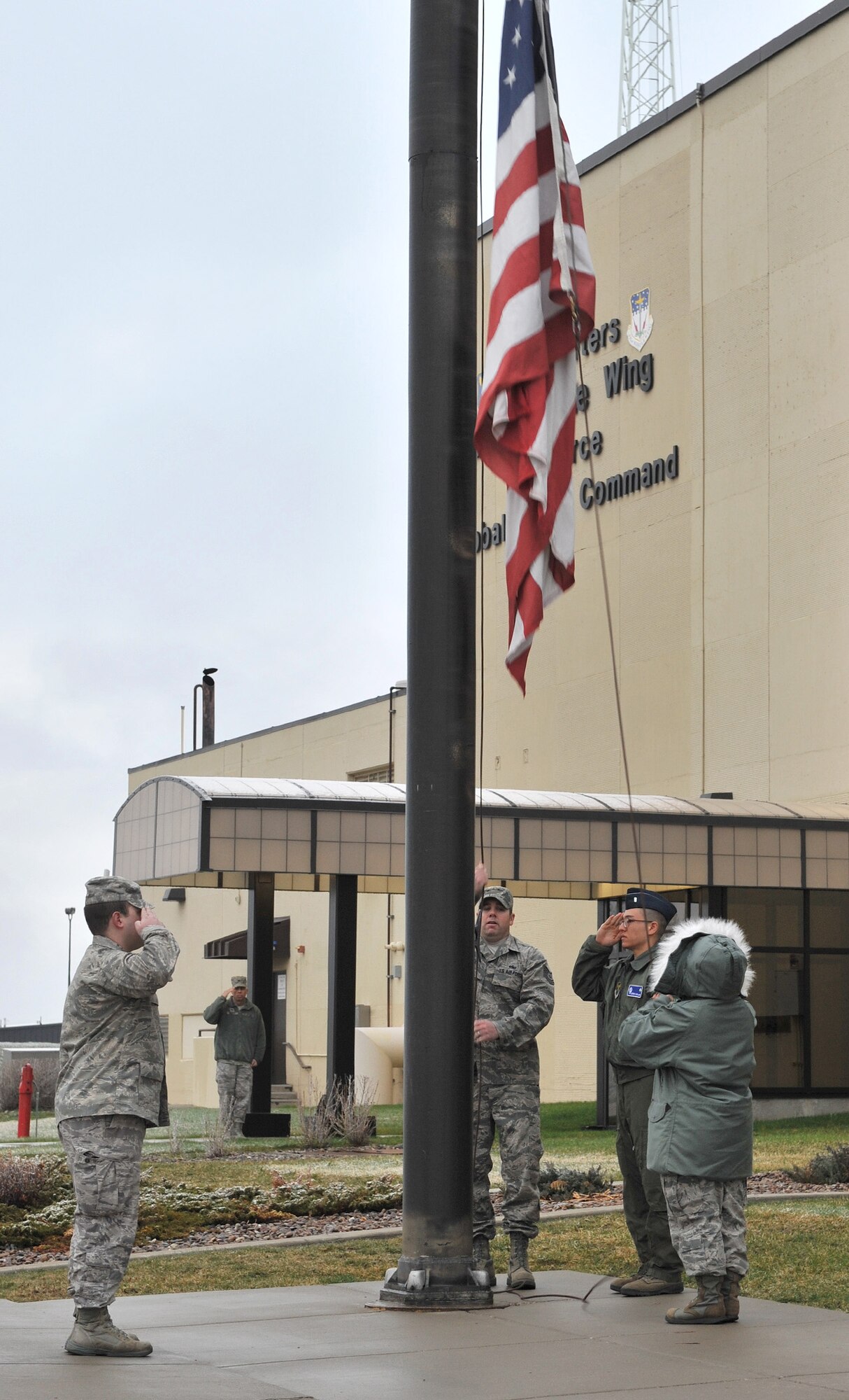 A detail from the 341st Operations Group raises the American flag in front of the 341st Missile Wing headquarters building April 15.  Pictured from left to right are 1st Lt. Alex Higdon, Tech. Sgt. Dan Staley, 1st Lt. Kiefer Caplan, and 1st Lt. Erlyn Rudico.  All are assigned to the 10th Missile Squadron.  (U.S. Air Force photo / John Turner)