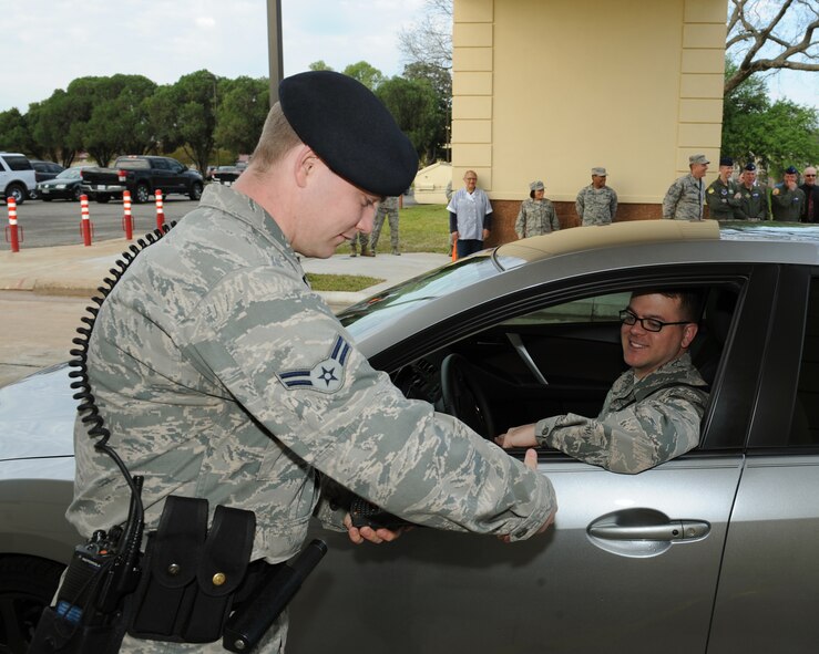 Airman 1st Class Jonathan Towney, 2nd Security Forces Squadron patrolman, scans the common access card of Senior Airman Jacob Mehlin, 2nd Operations Support Squadron intelligence analyst, at the re-opening of the North Gate on Barksdale Air Force Base, La., April 18, 2014. Mehlin was the first Airman to drive through the gate. (U.S. Air Force photo/Senior Airman Benjamin Gonsier)
